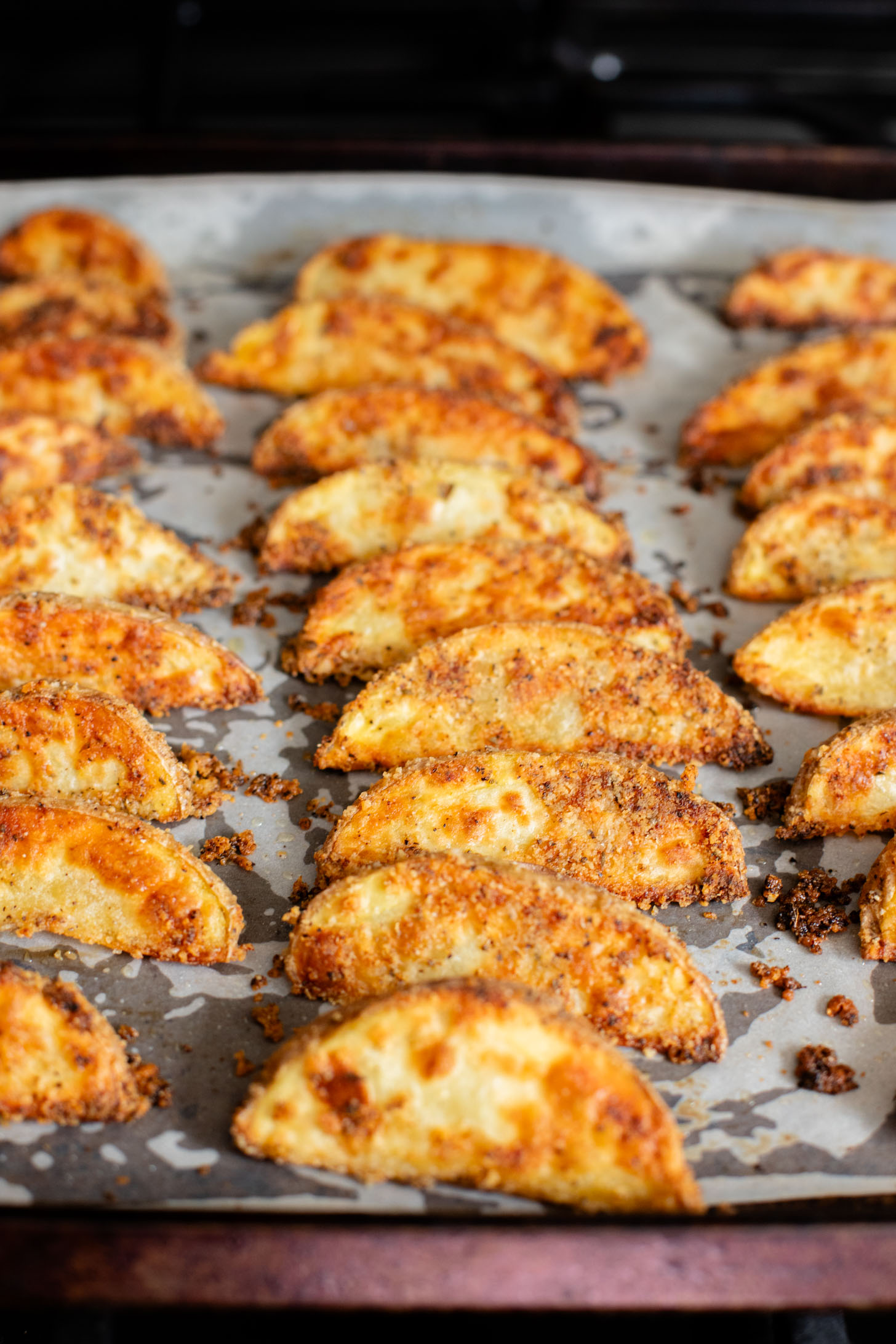 These Vegan Parmesan Crusted Potato Wedges are the most satisfying way to eat potatoes. Perfectly crispy and garlicky | ThisSavoryVegan.com