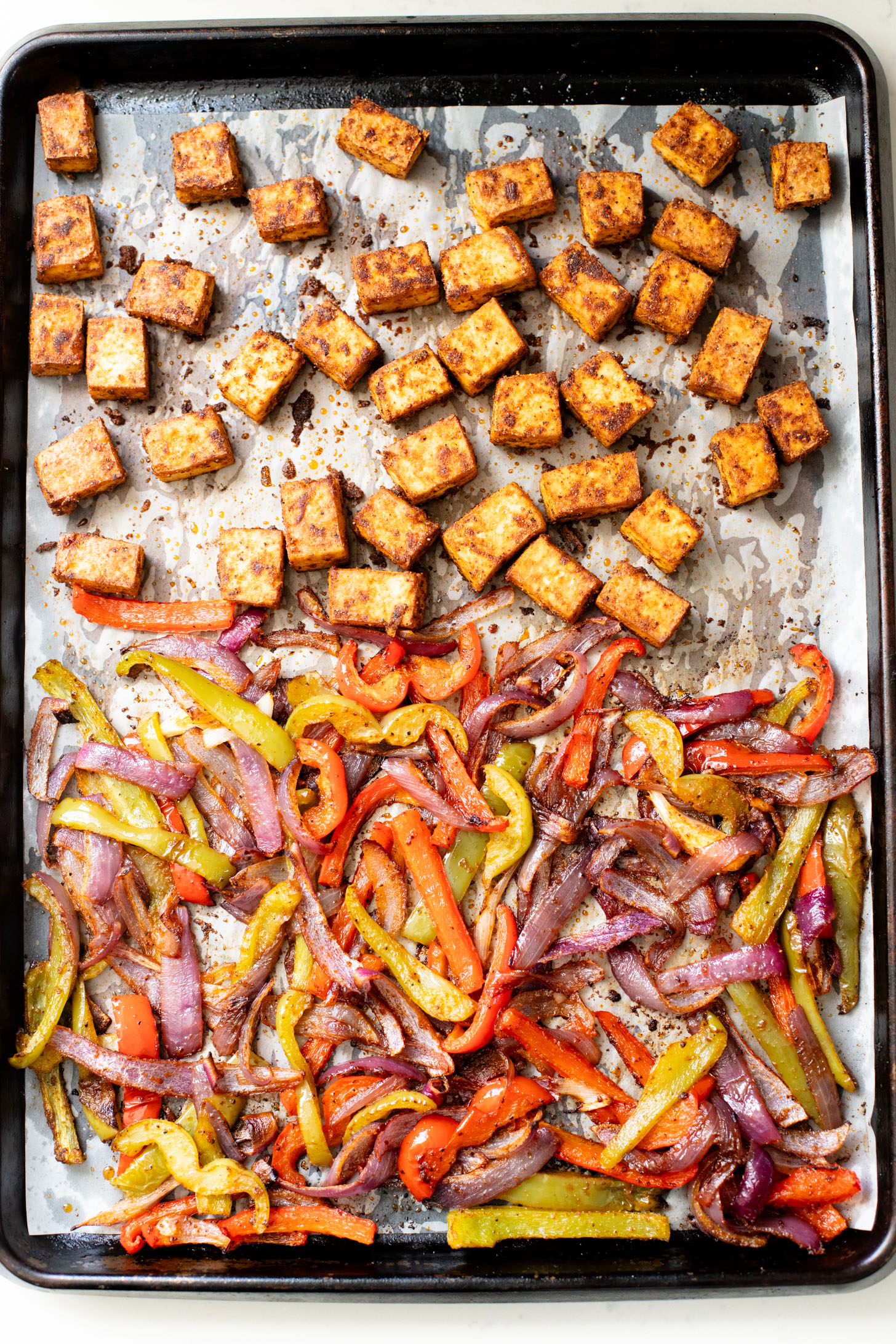 These Tofu Fajita Rice Bowls are a quick sheet pan dinner recipe! Packed with protein & veggies, and topped with avocado salsa | ThisSavoryVegan.com