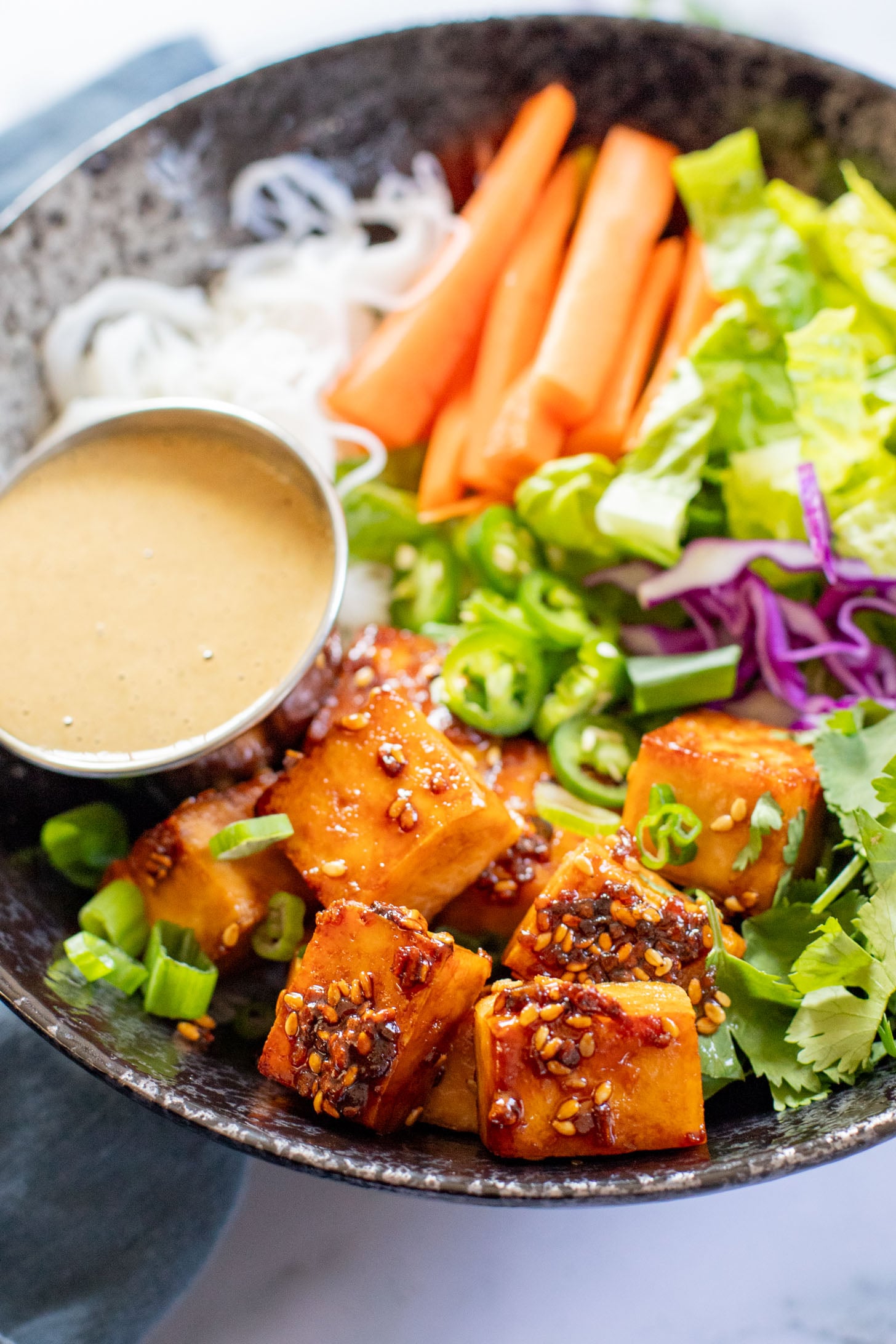 These Teriyaki Tofu Peanut Noodle Bowls are a mix between a salad and a bowl. Crispy tofu, lots of greens, rice noodles & peanut sauce | ThisSavoryVegan.com