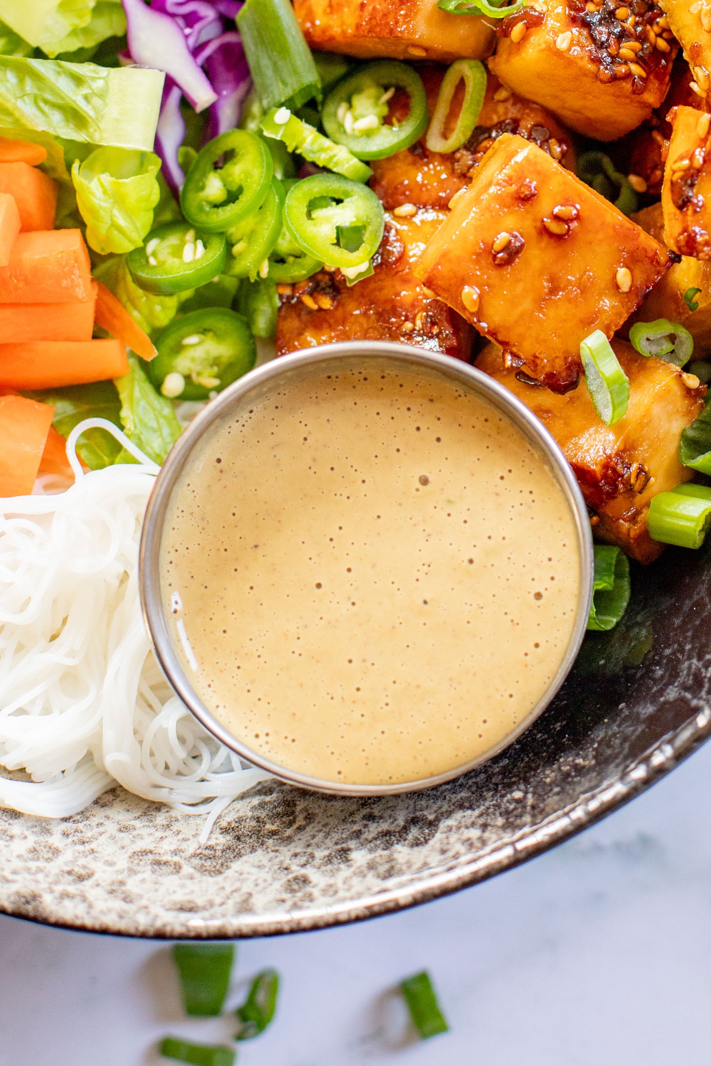 These Teriyaki Tofu Peanut Noodle Bowls are a mix between a salad and a bowl. Crispy tofu, lots of greens, rice noodles & peanut sauce | ThisSavoryVegan.com