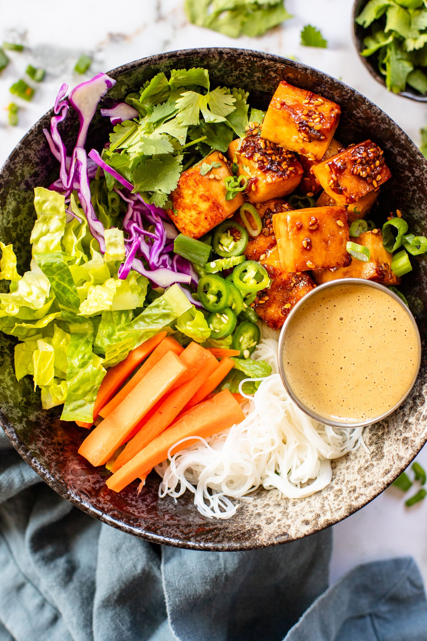 These Teriyaki Tofu Peanut Noodle Bowls are a mix between a salad and a bowl. Crispy tofu, lots of greens, rice noodles & peanut sauce | ThisSavoryVegan.com