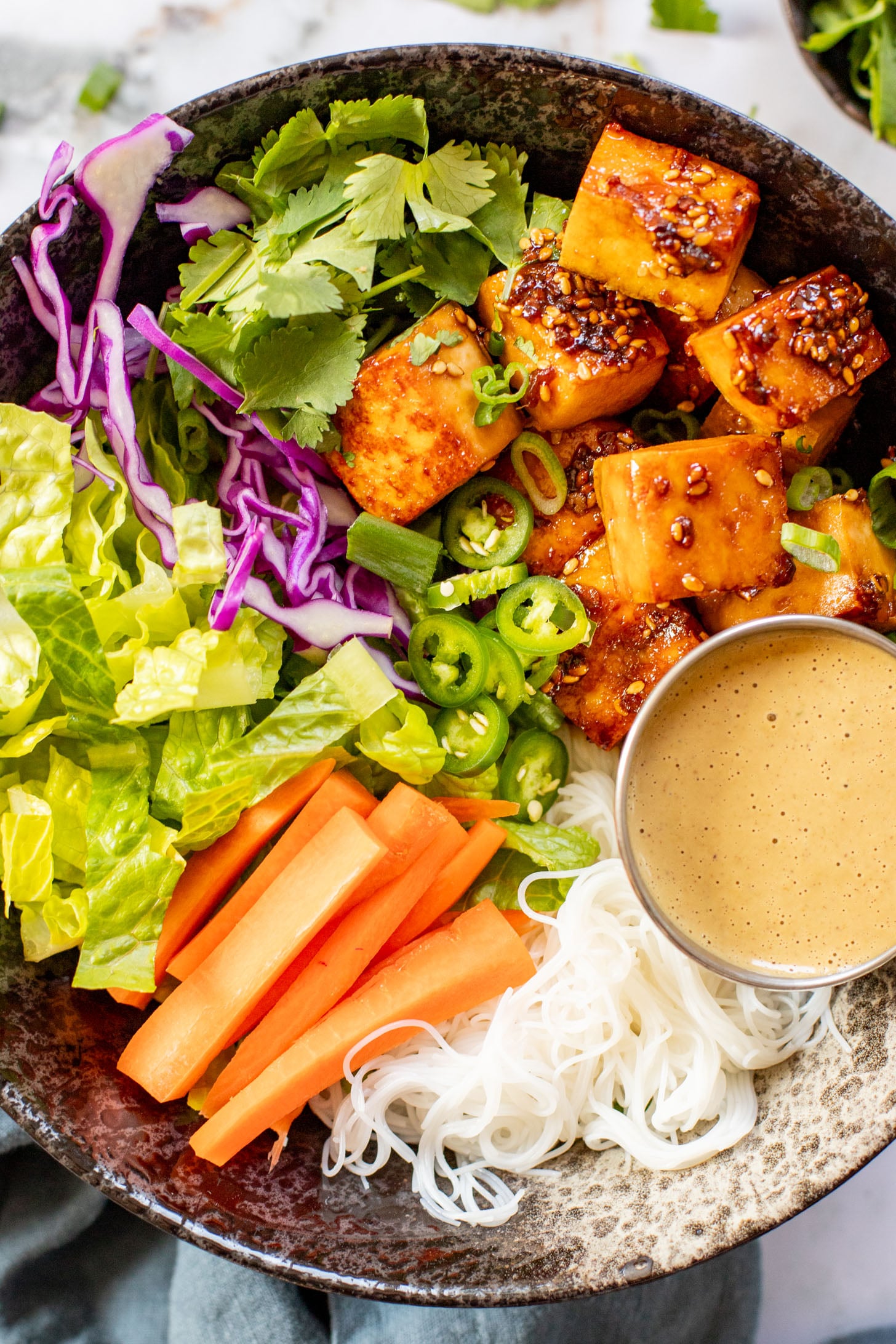 These Teriyaki Tofu Peanut Noodle Bowls are a mix between a salad and a bowl. Crispy tofu, lots of greens, rice noodles & peanut sauce | ThisSavoryVegan.com