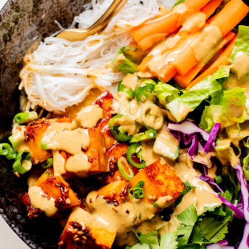 These Teriyaki Tofu Peanut Noodle Bowls are a mix between a salad and a bowl. Crispy tofu, lots of greens, rice noodles & peanut sauce | ThisSavoryVegan.com
