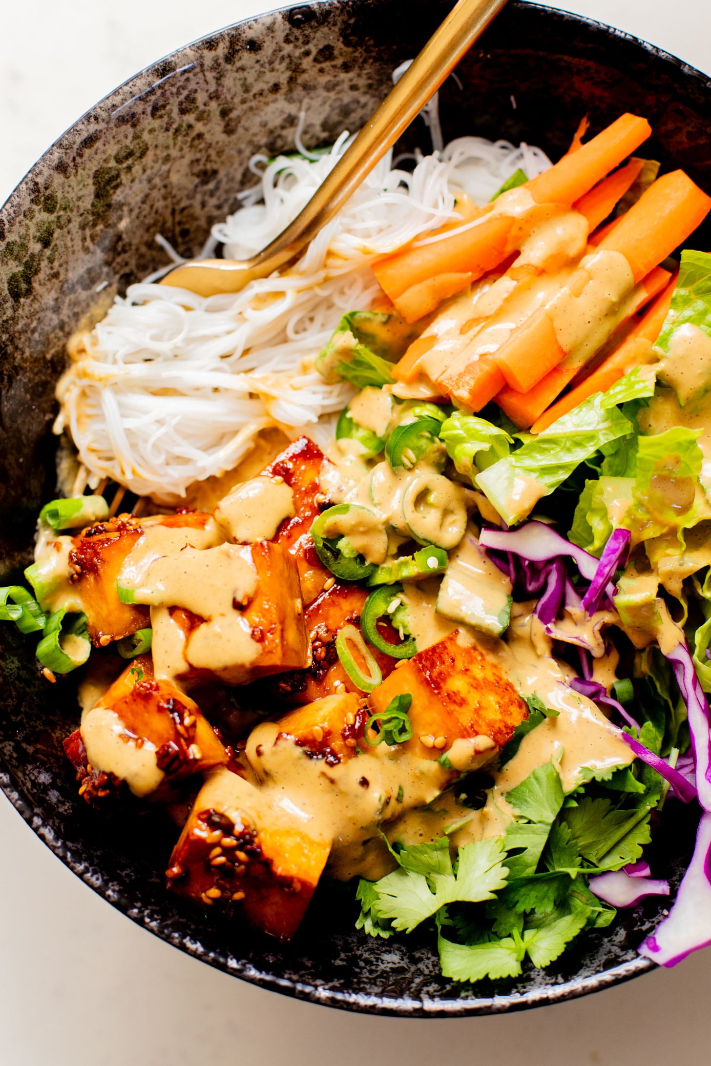 These Teriyaki Tofu Peanut Noodle Bowls are a mix between a salad and a bowl. Crispy tofu, lots of greens, rice noodles & peanut sauce | ThisSavoryVegan.com