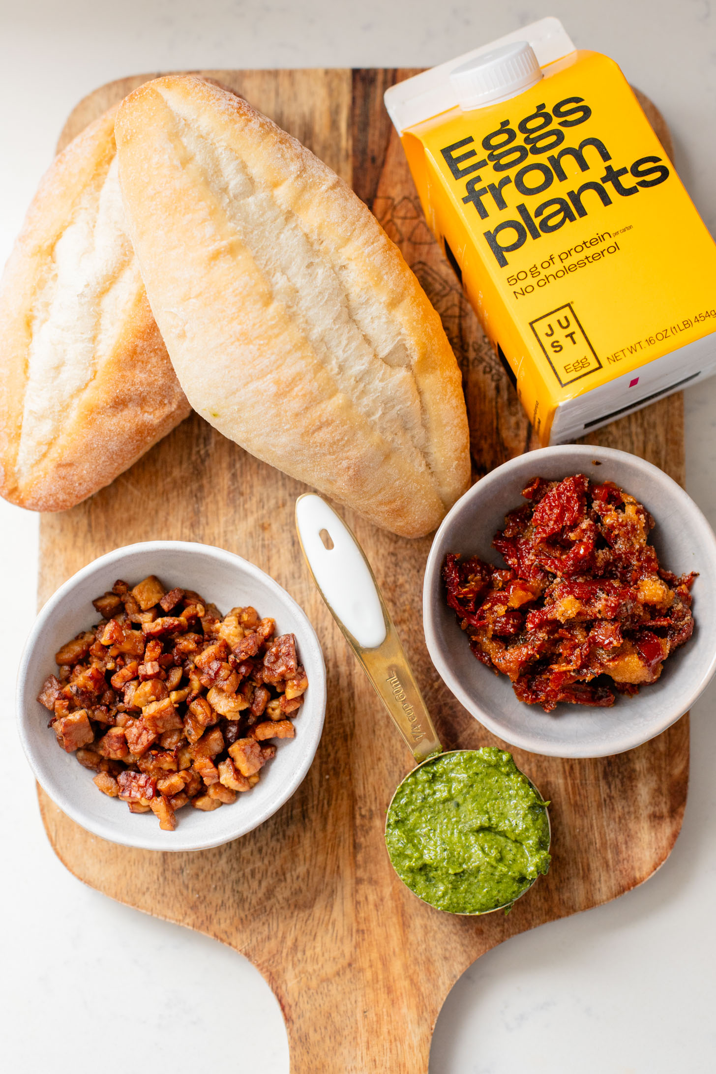 These Baked Vegan Egg Boats are filled with Just egg, pesto, sun-dried tomatoes & tempeh bacon. Perfect for a vegan brunch | ThisSavoryVegan.com