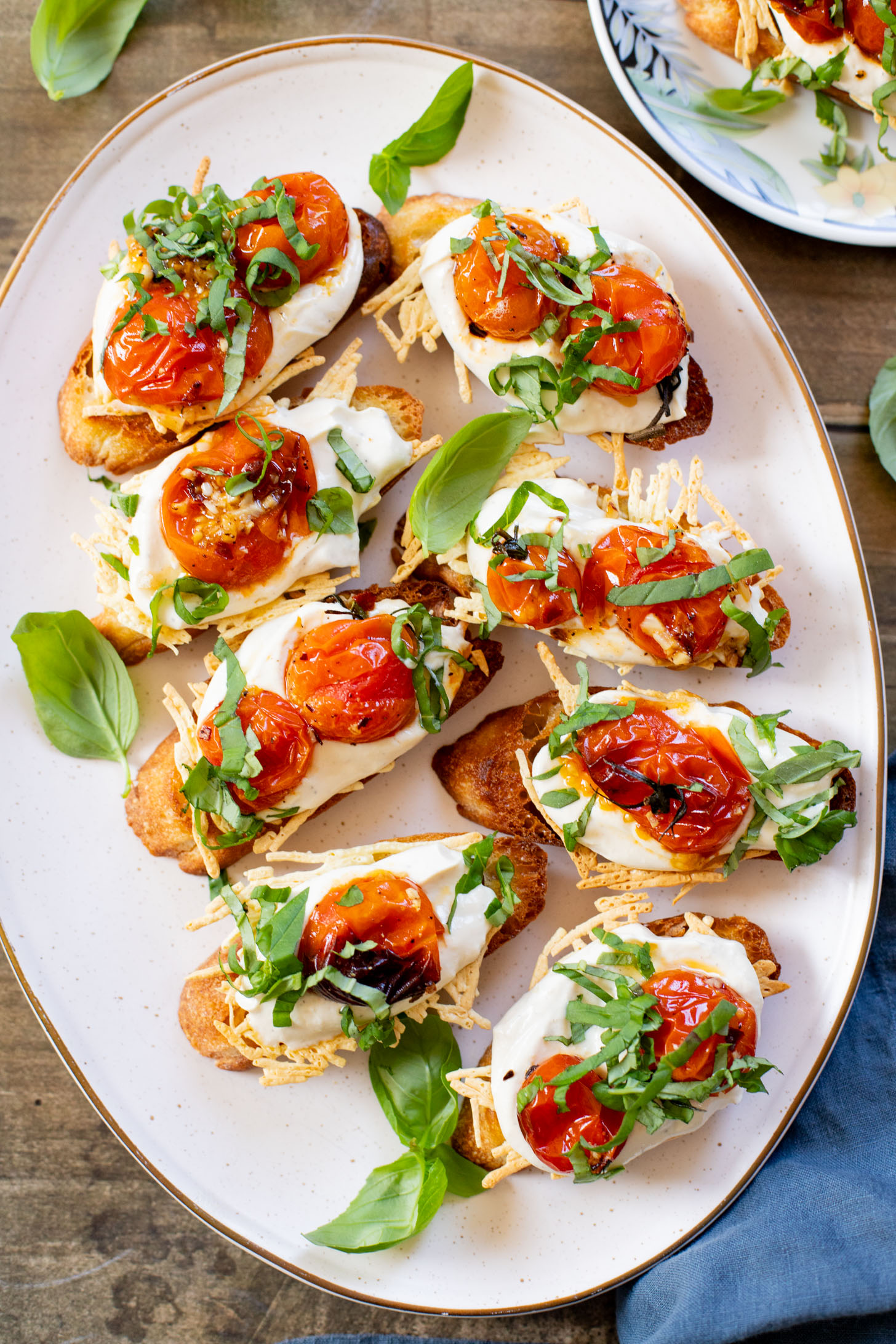 These Roasted Tomato & Ricotta Crostini are the best dairy-free appetizer! Bread slices are topped with vegan parm, tofu ricotta & burst tomatoes | ThisSavoryVegan.com