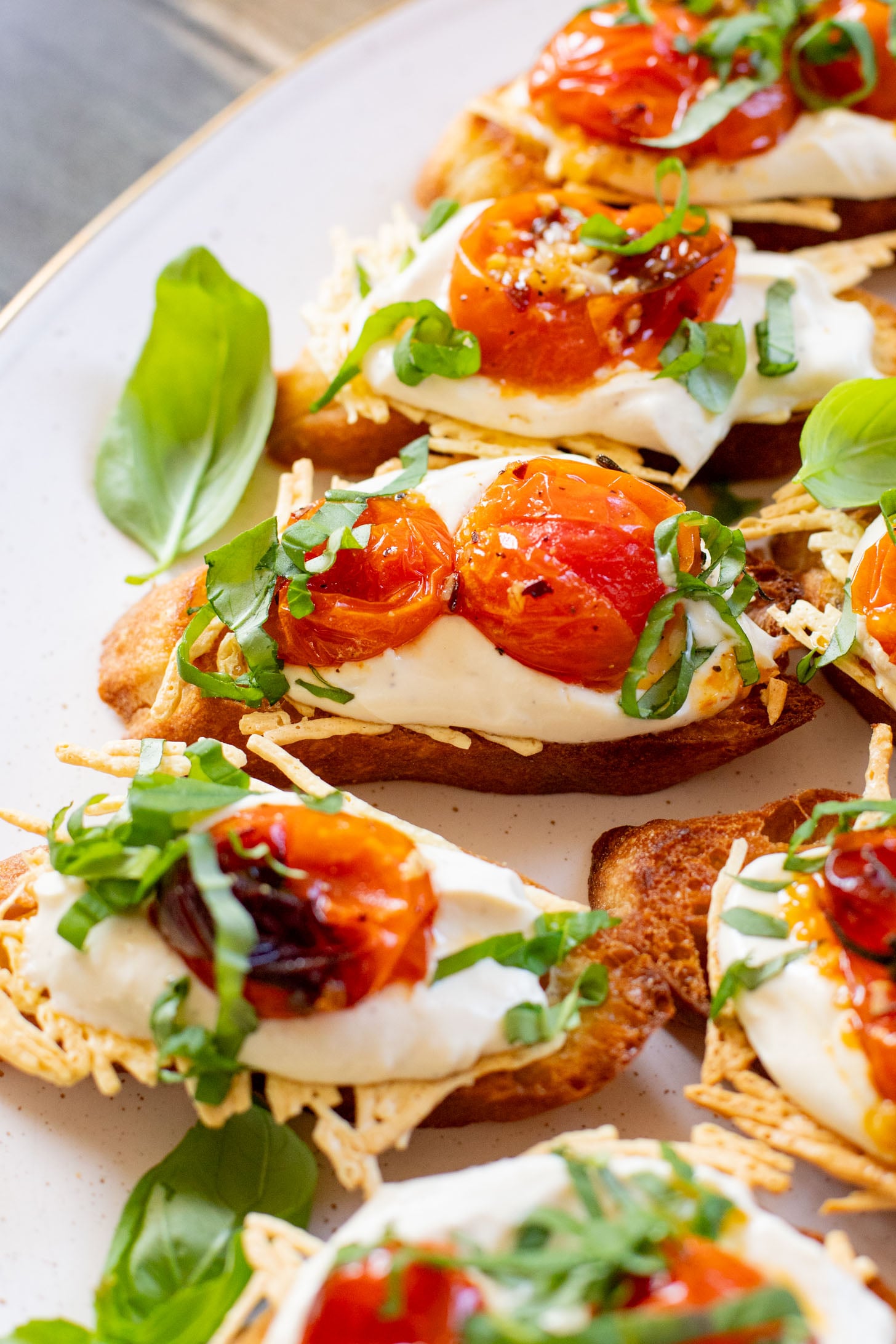 These Roasted Tomato & Ricotta Crostini are the best dairy-free appetizer! Bread slices are topped with vegan parm, tofu ricotta & burst tomatoes | ThisSavoryVegan.com