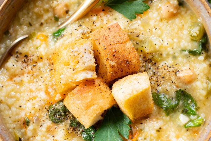 This Creamy Lemon Couscous Soup is bright and fresh. Made with a delicious broth, veggies, chickpeas, couscous and plenty of lemon juice | ThisSavoryVegan.com