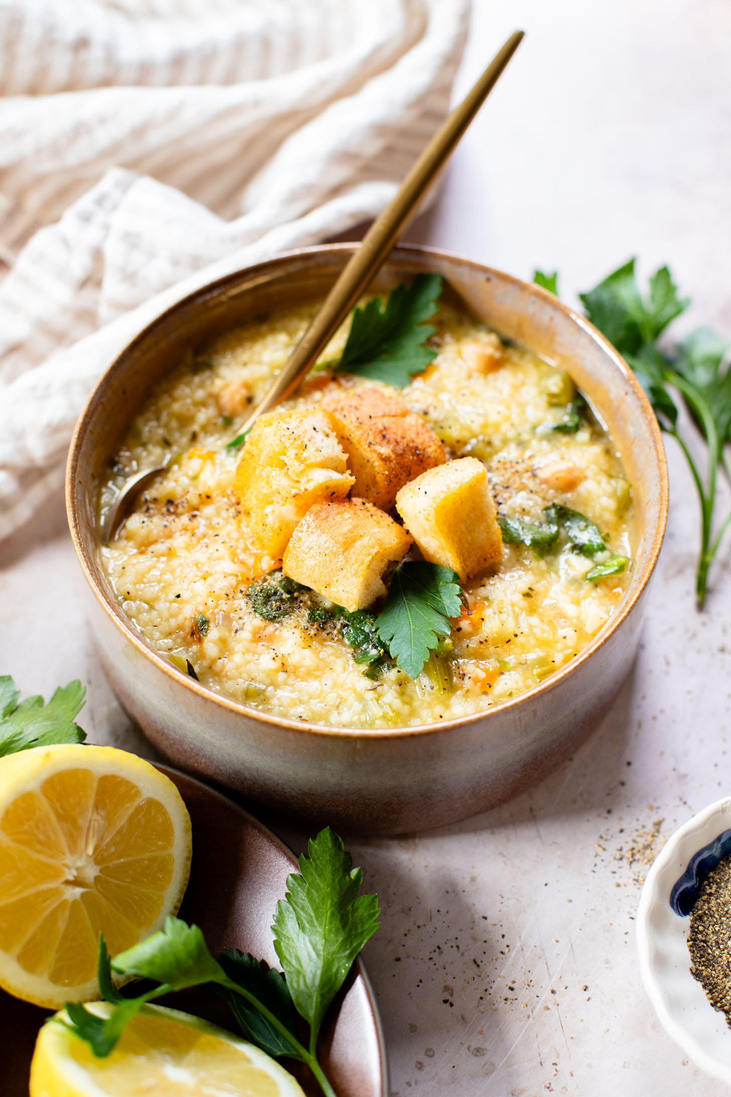 This Creamy Lemon Couscous Soup is bright and fresh. Made with a delicious broth, veggies, chickpeas, couscous and plenty of lemon juice | ThisSavoryVegan.com