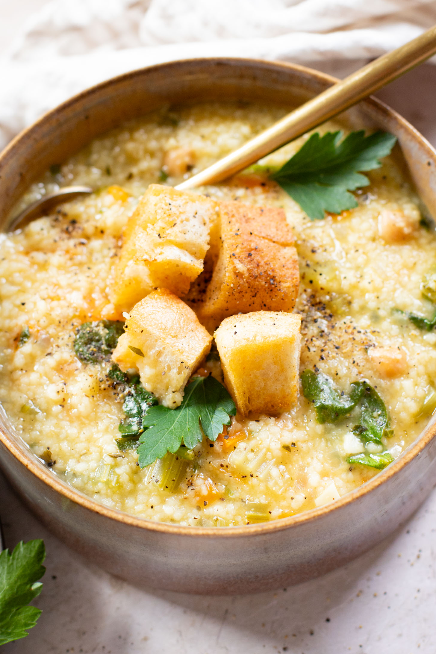 This Creamy Lemon Couscous Soup is bright and fresh. Made with a delicious broth, veggies, chickpeas, couscous and plenty of lemon juice | ThisSavoryVegan.com