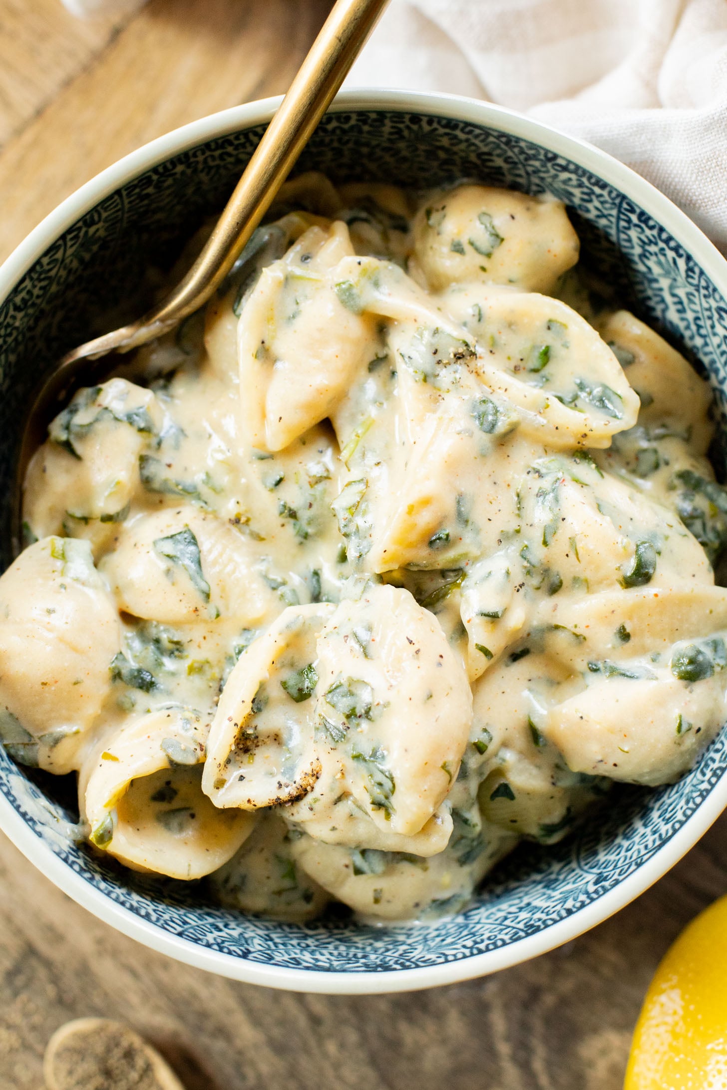 This Creamy Spinach Tofu Shells recipe is a comforting vegan pasta that sneaks in protein & veggies. Made in one pot for easy clean up | ThisSavoryVegan.com