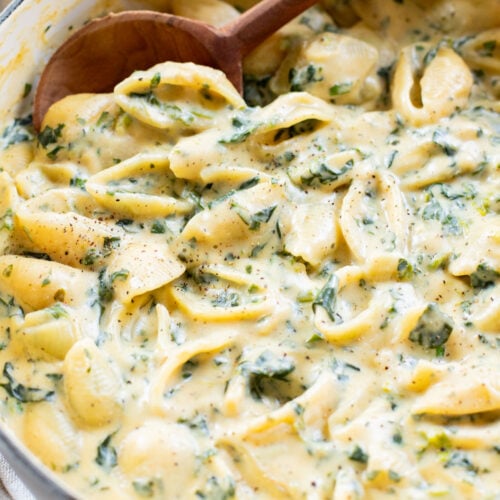 This Creamy Spinach Tofu Shells recipe is a comforting vegan pasta that sneaks in protein & veggies. Made in one pot for easy clean up | ThisSavoryVegan.com