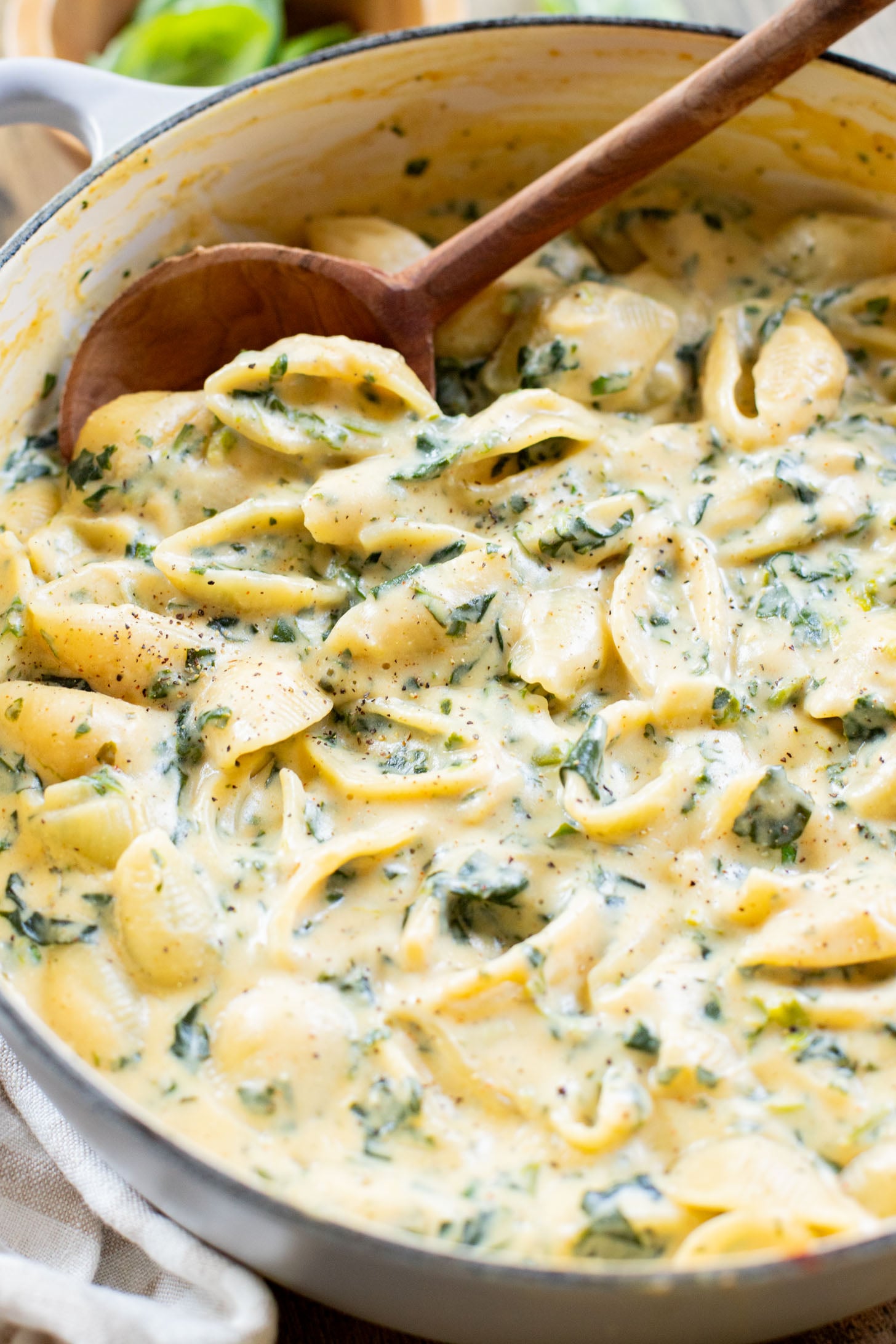 This Creamy Spinach Tofu Shells recipe is a comforting vegan pasta that sneaks in protein & veggies. Made in one pot for easy clean up | ThisSavoryVegan.com