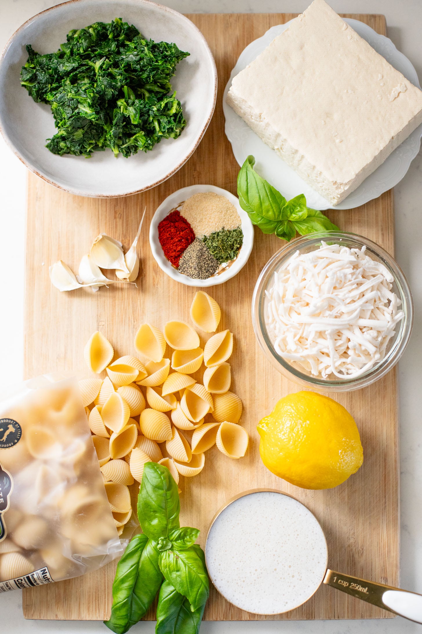This Creamy Spinach Tofu Shells recipe is a comforting vegan pasta that sneaks in protein & veggies. Made in one pot for easy clean up | ThisSavoryVegan.com