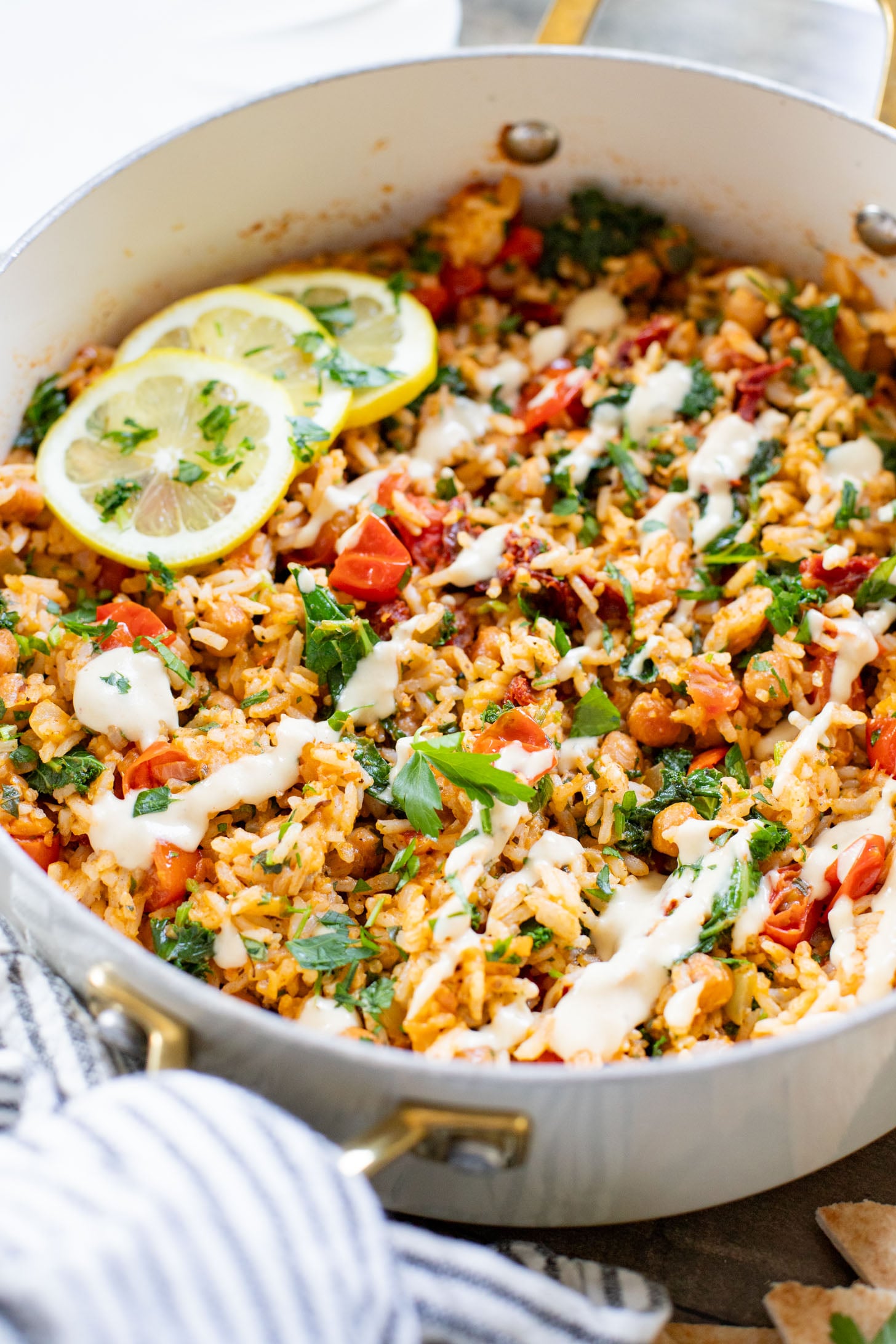 This Mediterranean Chickpea & Rice Skillet is a quick & delicious vegan dinner. Crispy chickpeas, veggies, rice & a lemony hummus sauce | ThisSavoryVegan.com