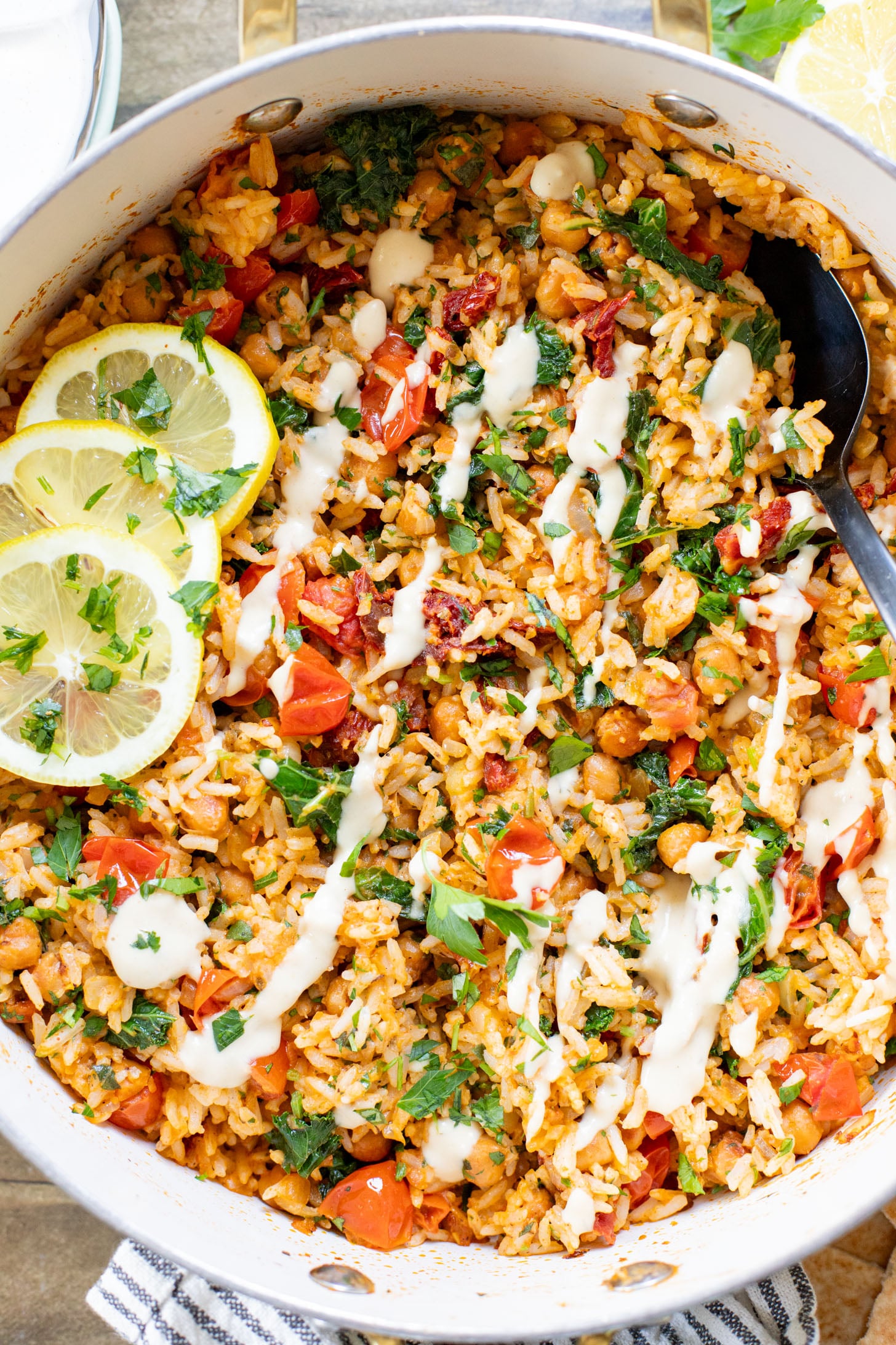 This Mediterranean Chickpea & Rice Skillet is a quick & delicious vegan dinner. Crispy chickpeas, veggies, rice & a lemony hummus sauce | ThisSavoryVegan.com