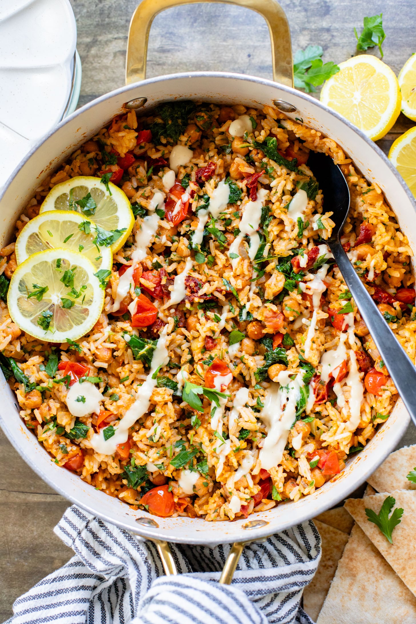 This Mediterranean Chickpea & Rice Skillet is a quick & delicious vegan dinner. Crispy chickpeas, veggies, rice & a lemony hummus sauce | ThisSavoryVegan.com