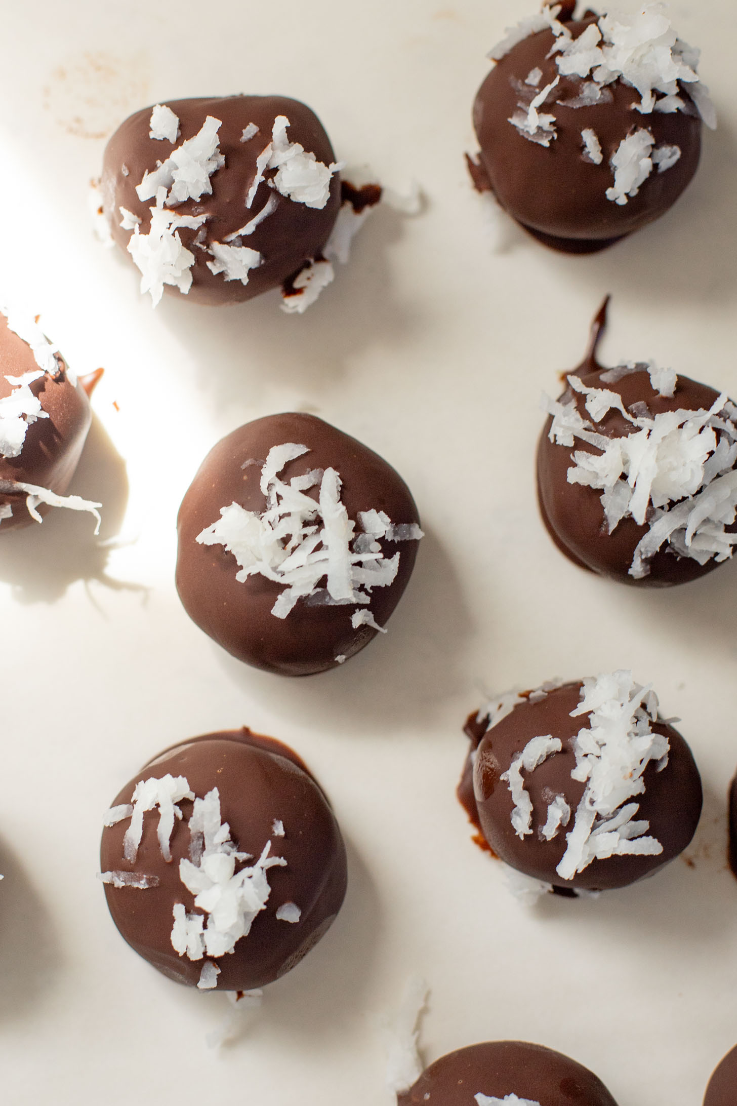 These Almond Coconut Date Balls are a protein-packed vegan dessert or snack that everyone will love! Dipped in chocolate & sprinkled with coconut | ThisSavoryVegan.com