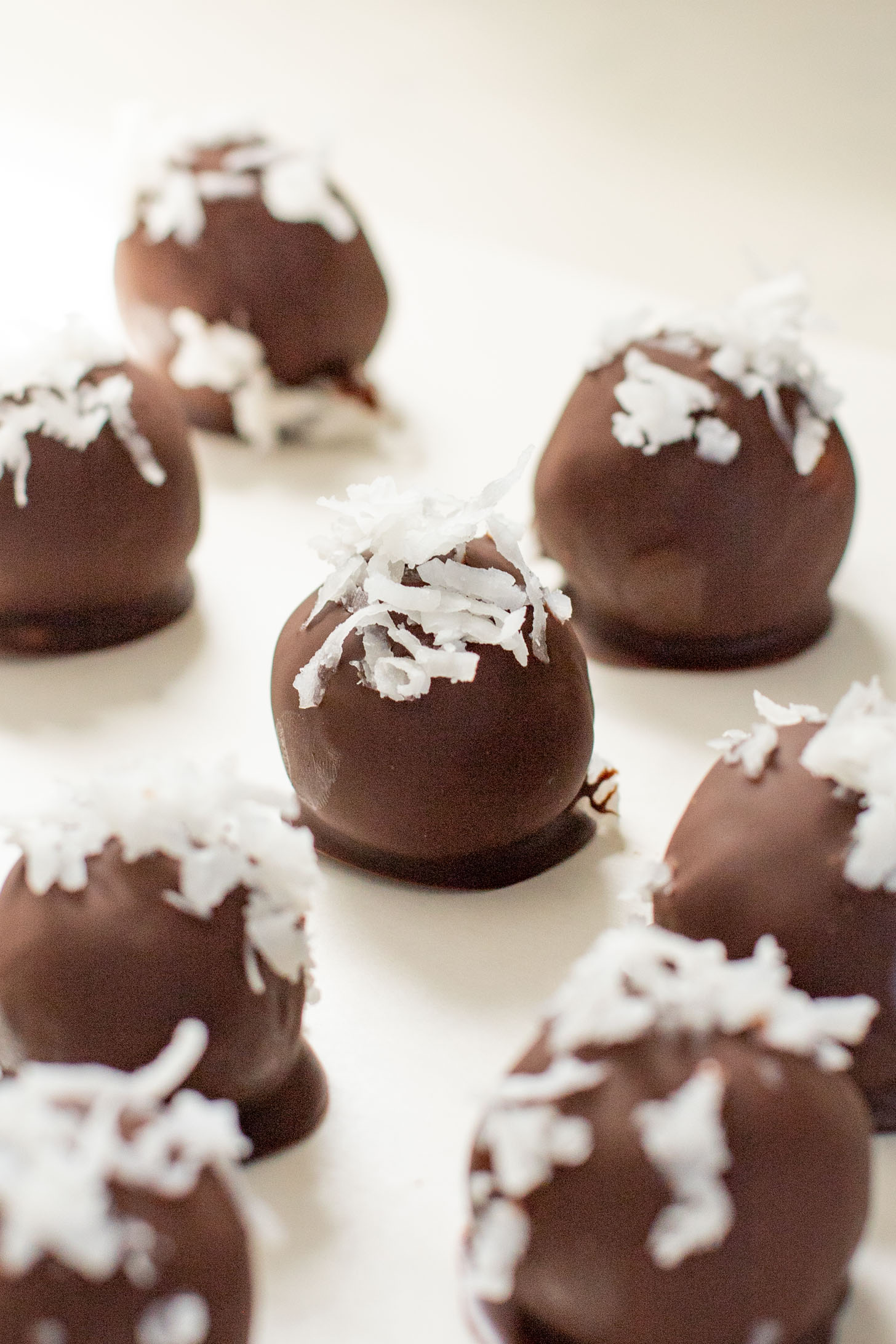 These Almond Coconut Date Balls are a protein-packed vegan dessert or snack that everyone will love! Dipped in chocolate & sprinkled with coconut | ThisSavoryVegan.com