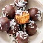 These Almond Coconut Date Balls are a protein-packed vegan dessert or snack that everyone will love! Dipped in chocolate & sprinkled with coconut | ThisSavoryVegan.com