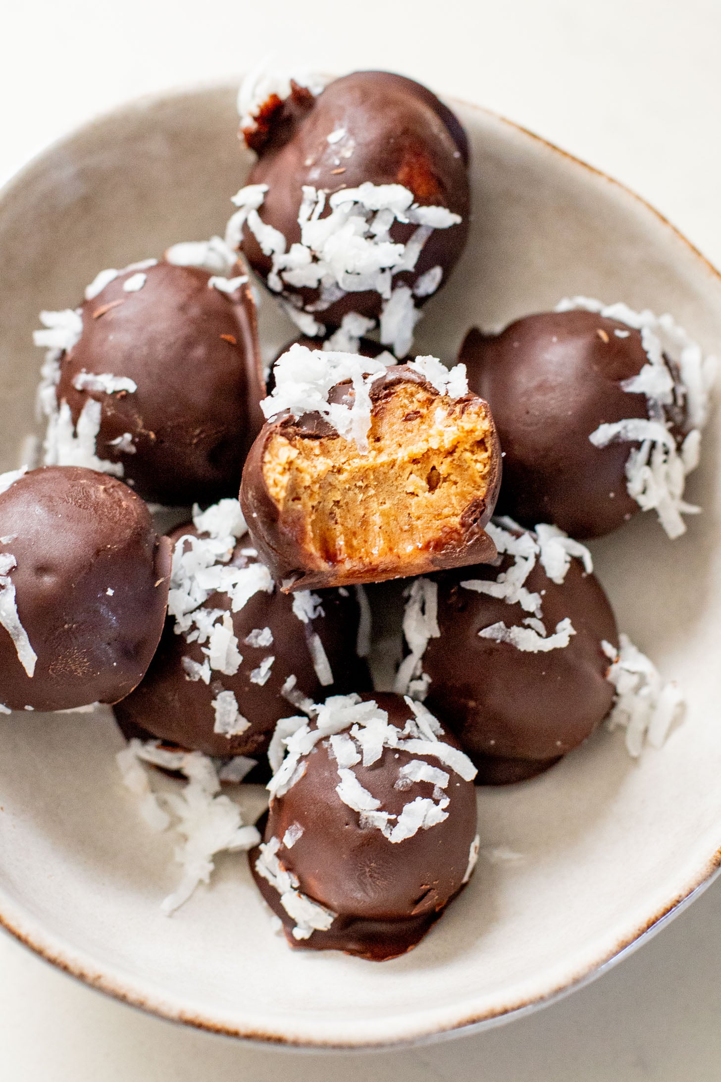 These Almond Coconut Date Balls are a protein-packed vegan dessert or snack that everyone will love! Dipped in chocolate & sprinkled with coconut | ThisSavoryVegan.com