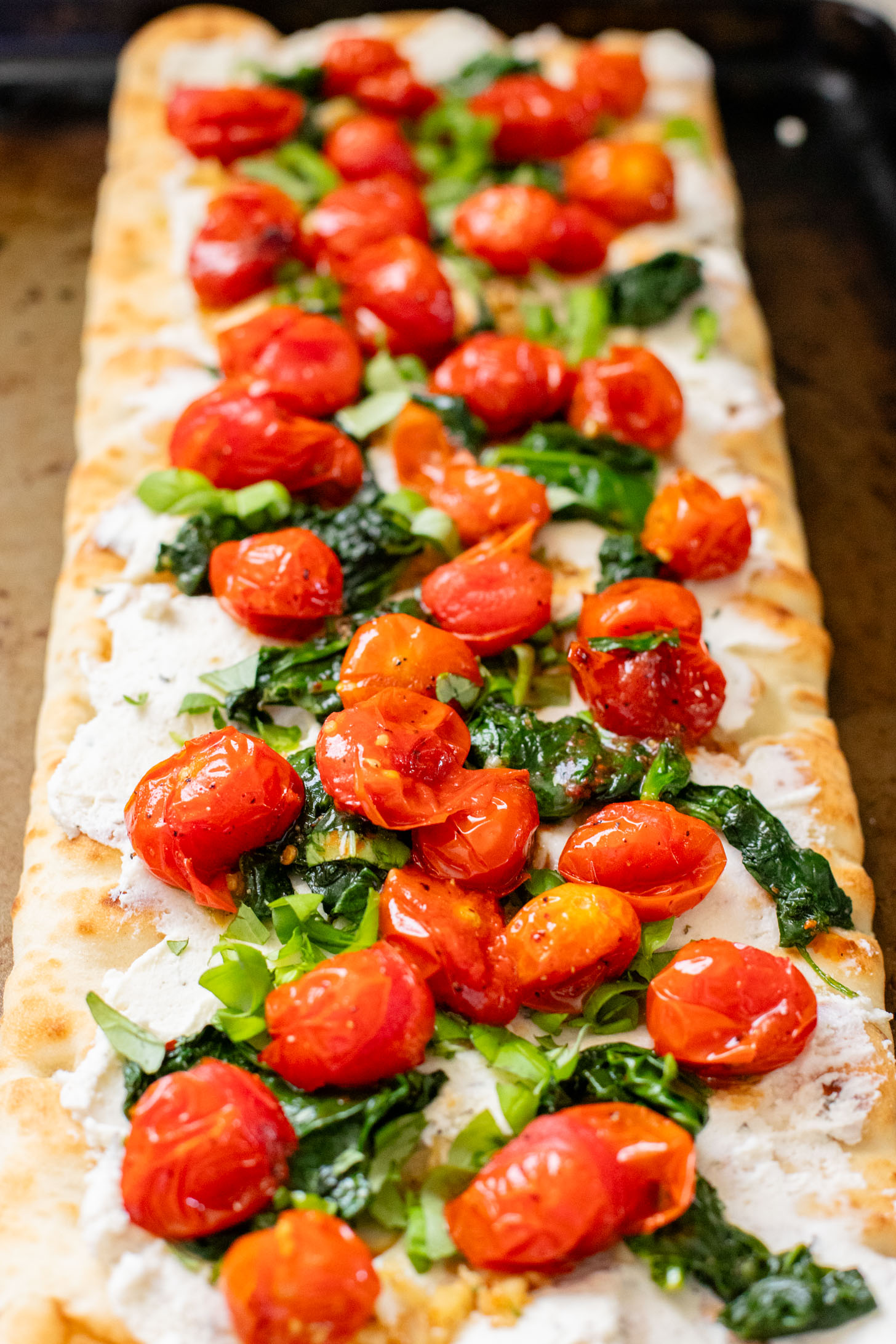 This Burst Tomato Flatbread is a delicious summer recipe! Made with dairy-free cheese and topped with balsamic burst cherry tomatoes | ThisSavoryVegan.com