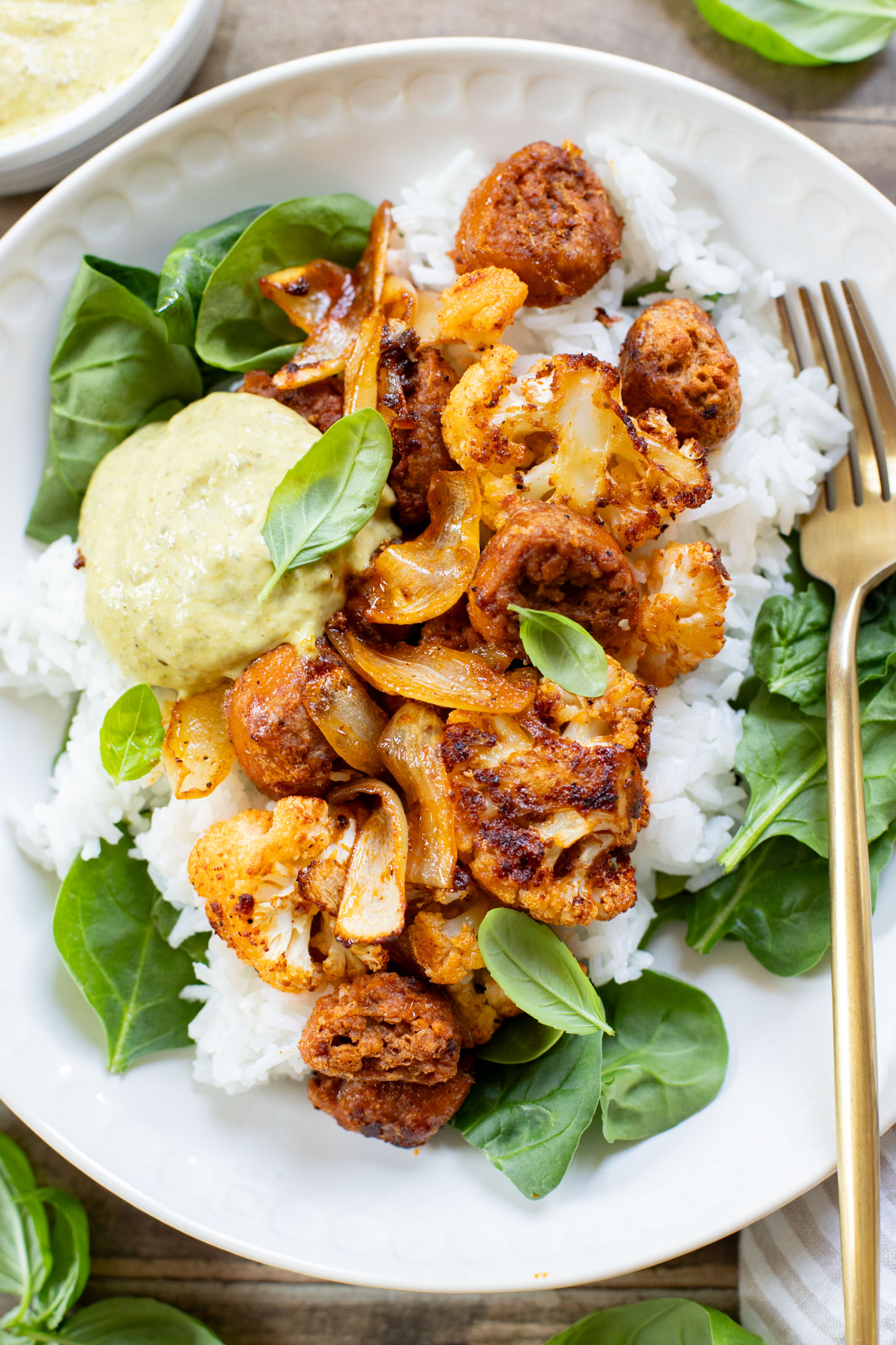 This Sheet Pan Vegan Sausage & Cauliflower is the perfect weeknight dinner. Served over rice with a pesto aioli | ThisSavoryVegan.com