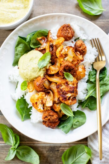 This Sheet Pan Vegan Sausage & Cauliflower is the perfect weeknight dinner. Served over rice with a pesto aioli | ThisSavoryVegan.com