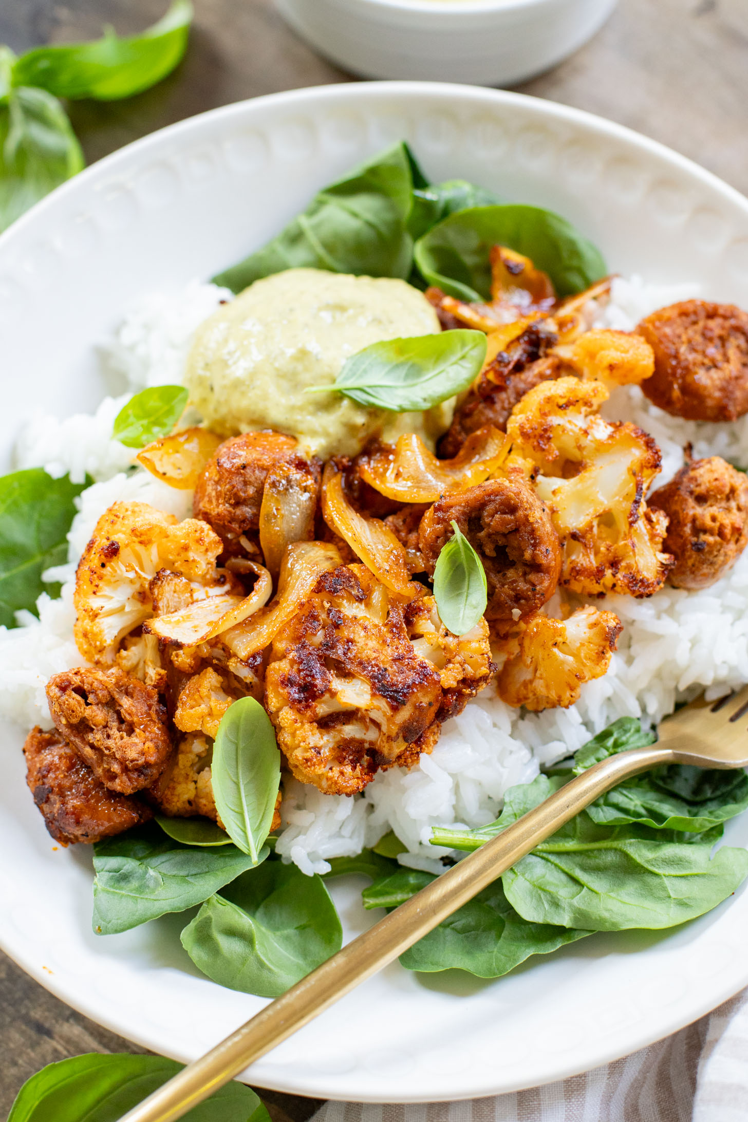 This Sheet Pan Vegan Sausage & Cauliflower is the perfect weeknight dinner. Served over rice with a pesto aioli | ThisSavoryVegan.com