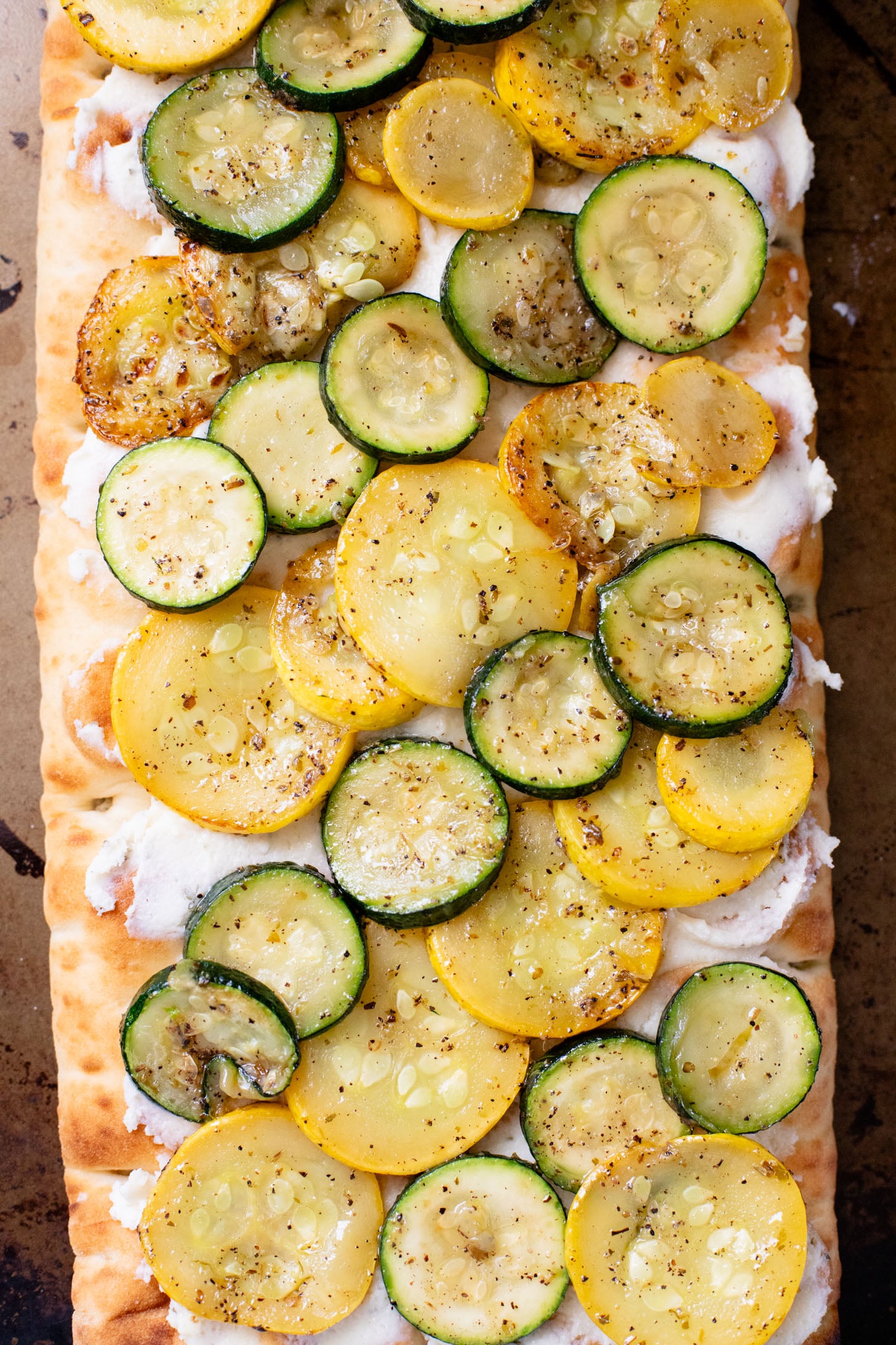 A yummy summer appetizer or quick dinner - this Cheesy Zucchini Flatbread is made with dairy-free cheese and zucchini slices | ThisSavoryVegan.com
