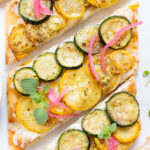 A yummy summer appetizer or quick dinner - this Cheesy Zucchini Flatbread is made with dairy-free cheese and zucchini slices | ThisSavoryVegan.com