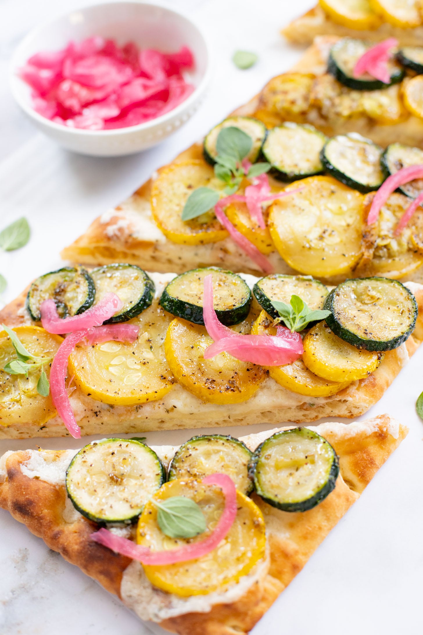 A yummy summer appetizer or quick dinner - this Cheesy Zucchini Flatbread is made with dairy-free cheese and zucchini slices | ThisSavoryVegan.com