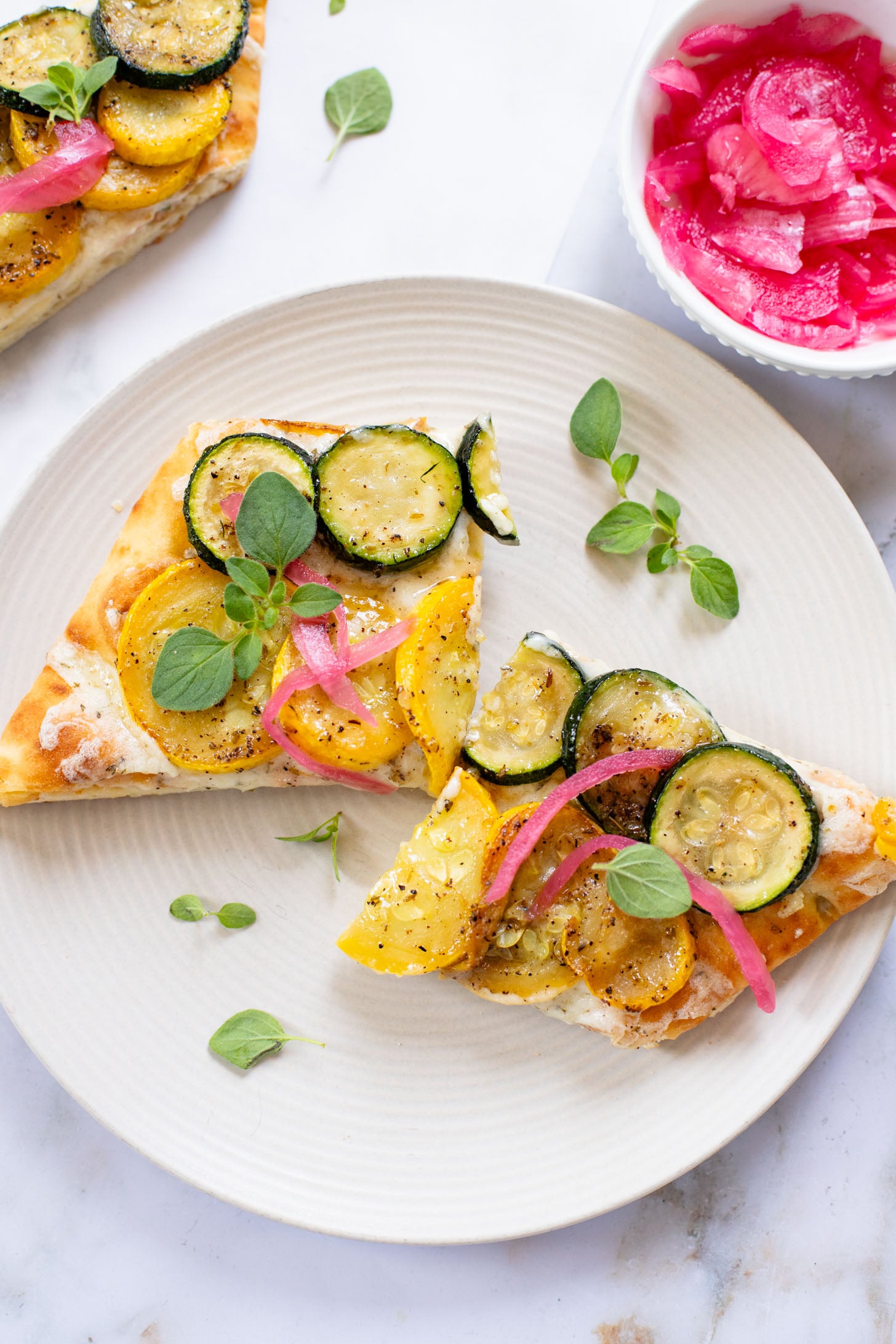 A yummy summer appetizer or quick dinner - this Cheesy Zucchini Flatbread is made with dairy-free cheese and zucchini slices | ThisSavoryVegan.com
