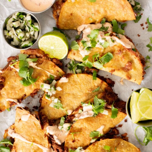 These Cheesy Bean Tacos are the perfect family weeknight dinner. Tortillas are stuffed with dairy-free cheese & beans and baked until crispy | ThisSavoryVegan.com