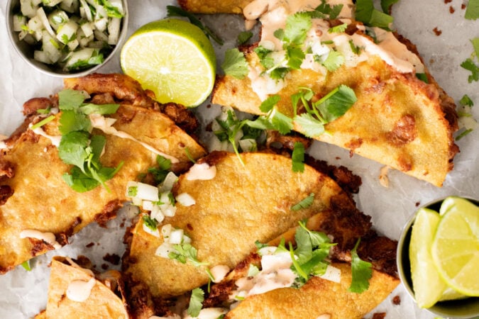 These Cheesy Bean Tacos are the perfect family weeknight dinner. Tortillas are stuffed with dairy-free cheese & beans and baked until crispy | ThisSavoryVegan.com