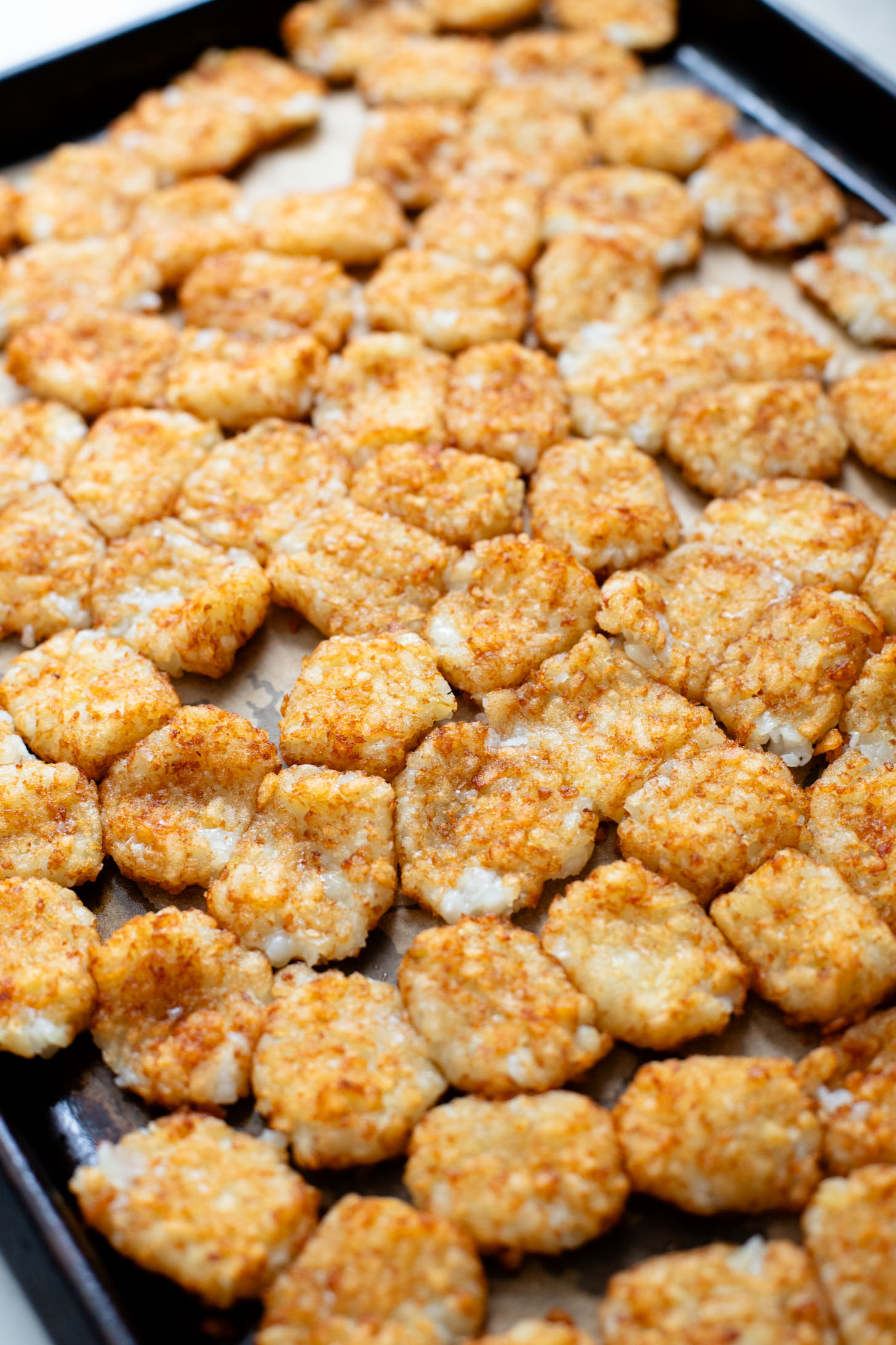 This Smashed Tater Tot Potato Salad is a party must make! The tots are crispy, the dressing is delicious and it is dairy-free | ThisSavoryVegan.com