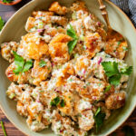 This Smashed Tater Tot Potato Salad is a party must make! The tots are crispy, the dressing is delicious and it is dairy-free | ThisSavoryVegan.com