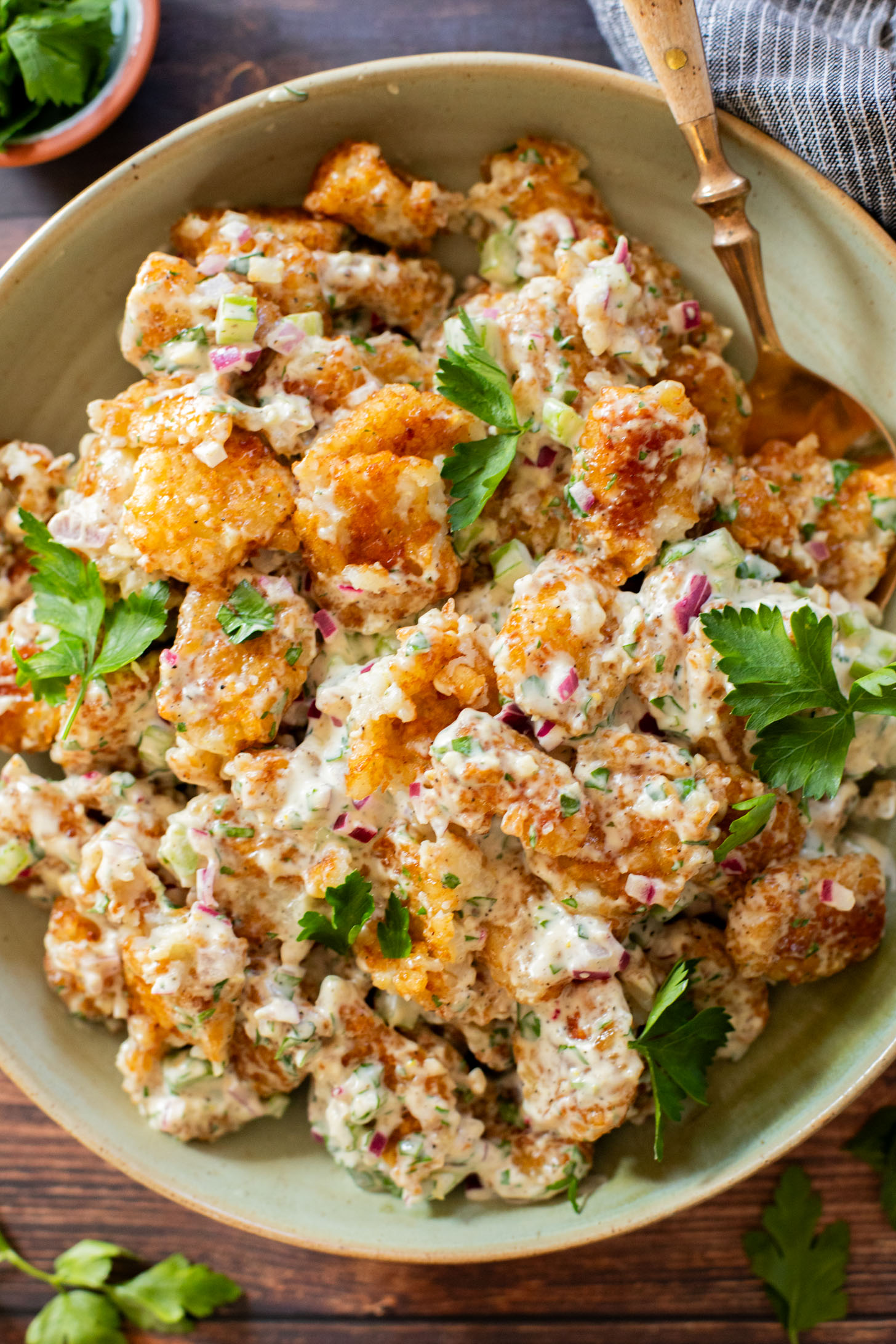 This Smashed Tater Tot Potato Salad is a party must make! The tots are crispy, the dressing is delicious and it is dairy-free | ThisSavoryVegan.com