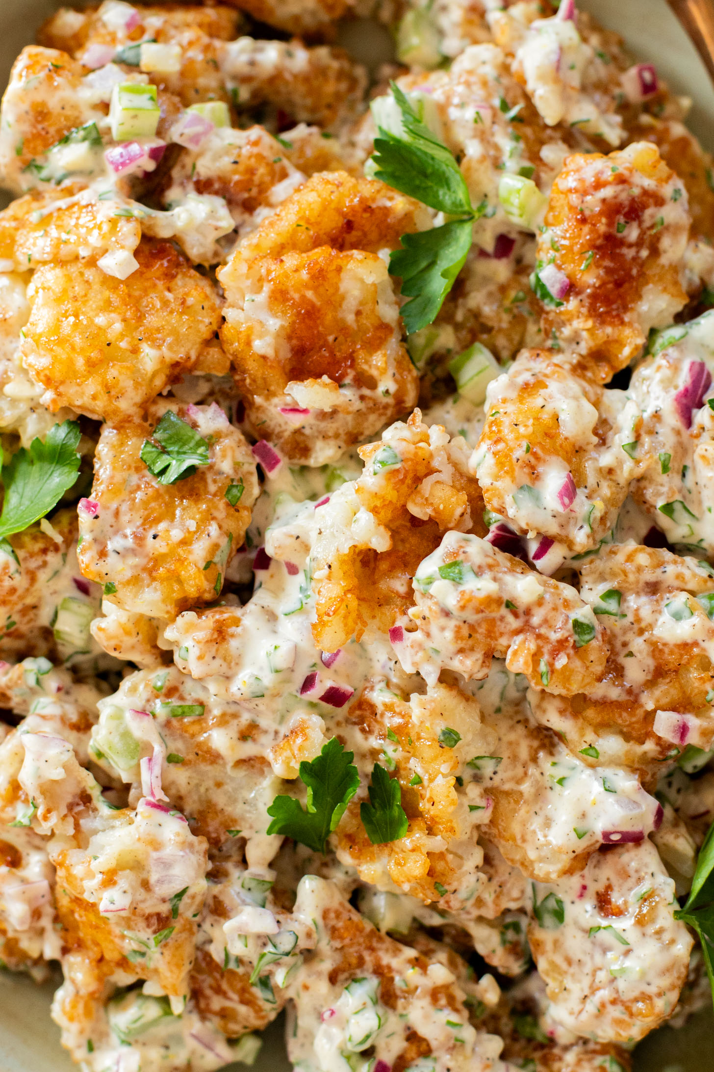 This Smashed Tater Tot Potato Salad is a party must make! The tots are crispy, the dressing is delicious and it is dairy-free | ThisSavoryVegan.com