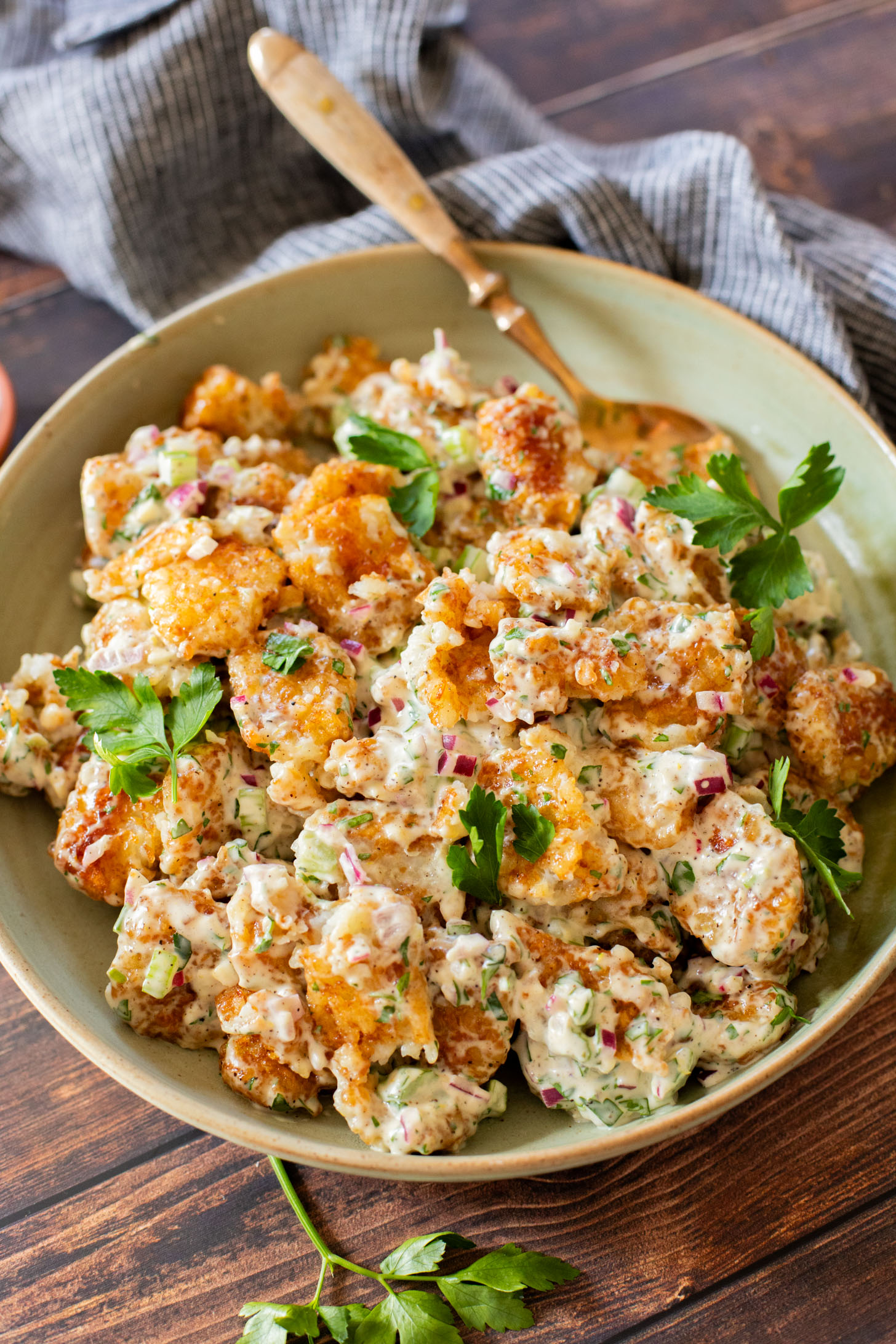 This Smashed Tater Tot Potato Salad is a party must make! The tots are crispy, the dressing is delicious and it is dairy-free | ThisSavoryVegan.com