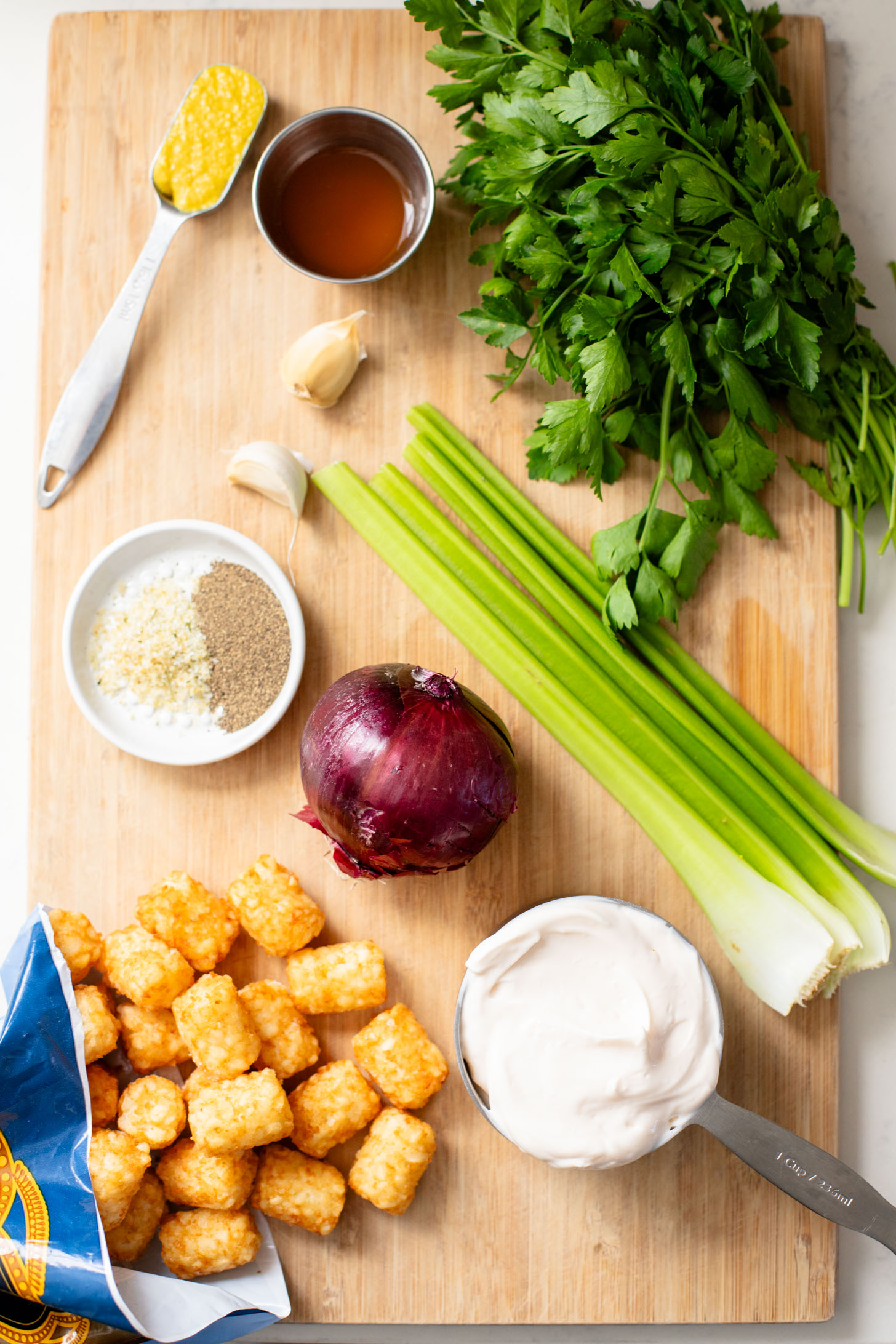 This Smashed Tater Tot Potato Salad is a party must make! The tots are crispy, the dressing is delicious and it is dairy-free | ThisSavoryVegan.com