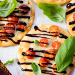 This Caprese Flatbread is a simple meal that packs in a ton of flavor. It is cheesy (and dairy-free), crispy, and simply delicious | ThisSavoryVegan.com