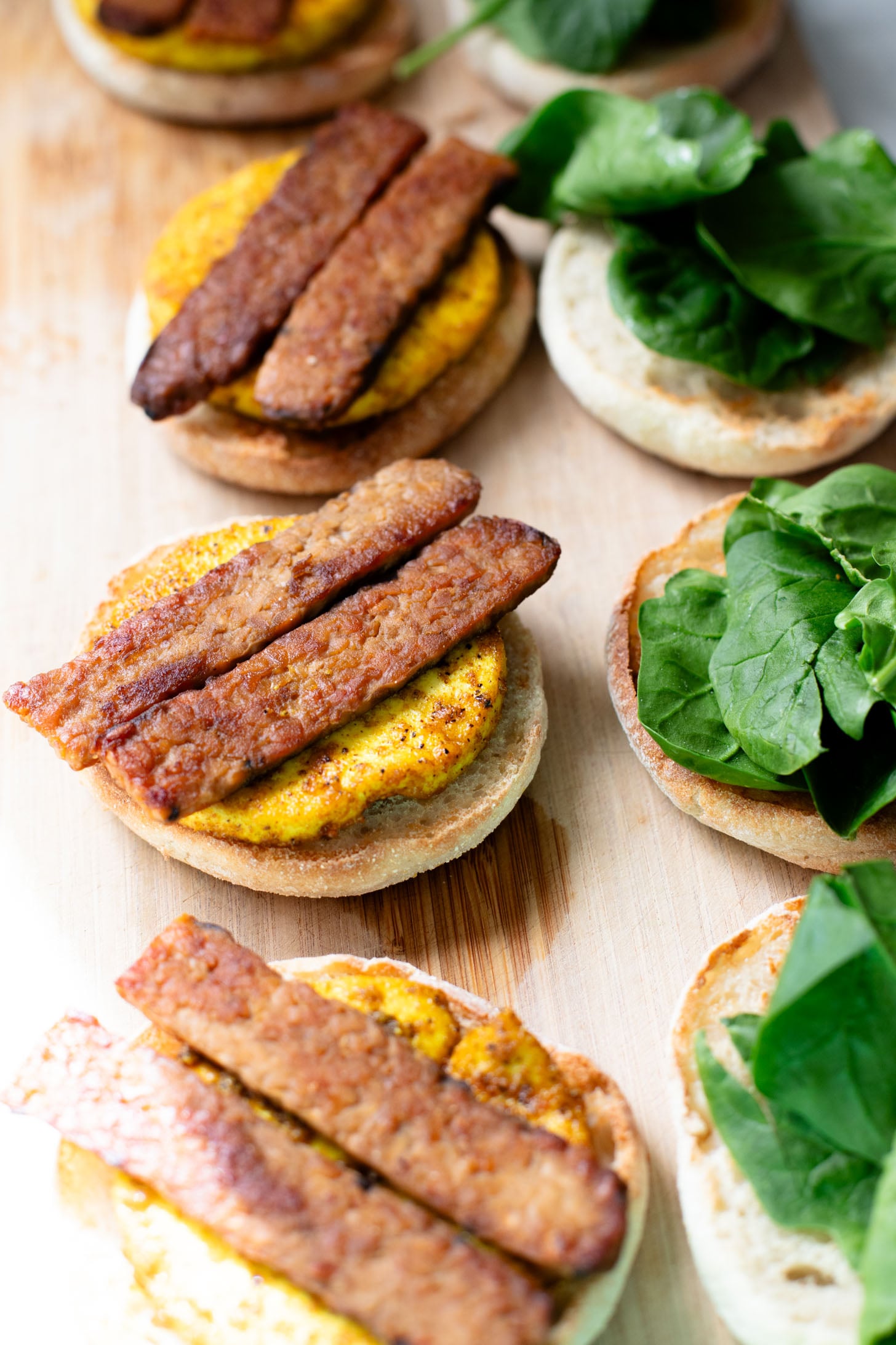 These Tofu Breakfast Sandwiches are the perfect breakfast on the go. Layered with seasoned tofu, tempeh bacon and spinach | ThisSavoryVegan.com