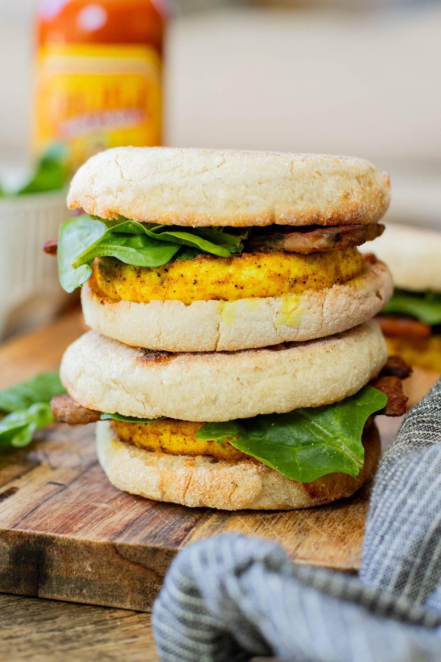 These Tofu Breakfast Sandwiches are the perfect breakfast on the go. Layered with seasoned tofu, tempeh bacon and spinach | ThisSavoryVegan.com