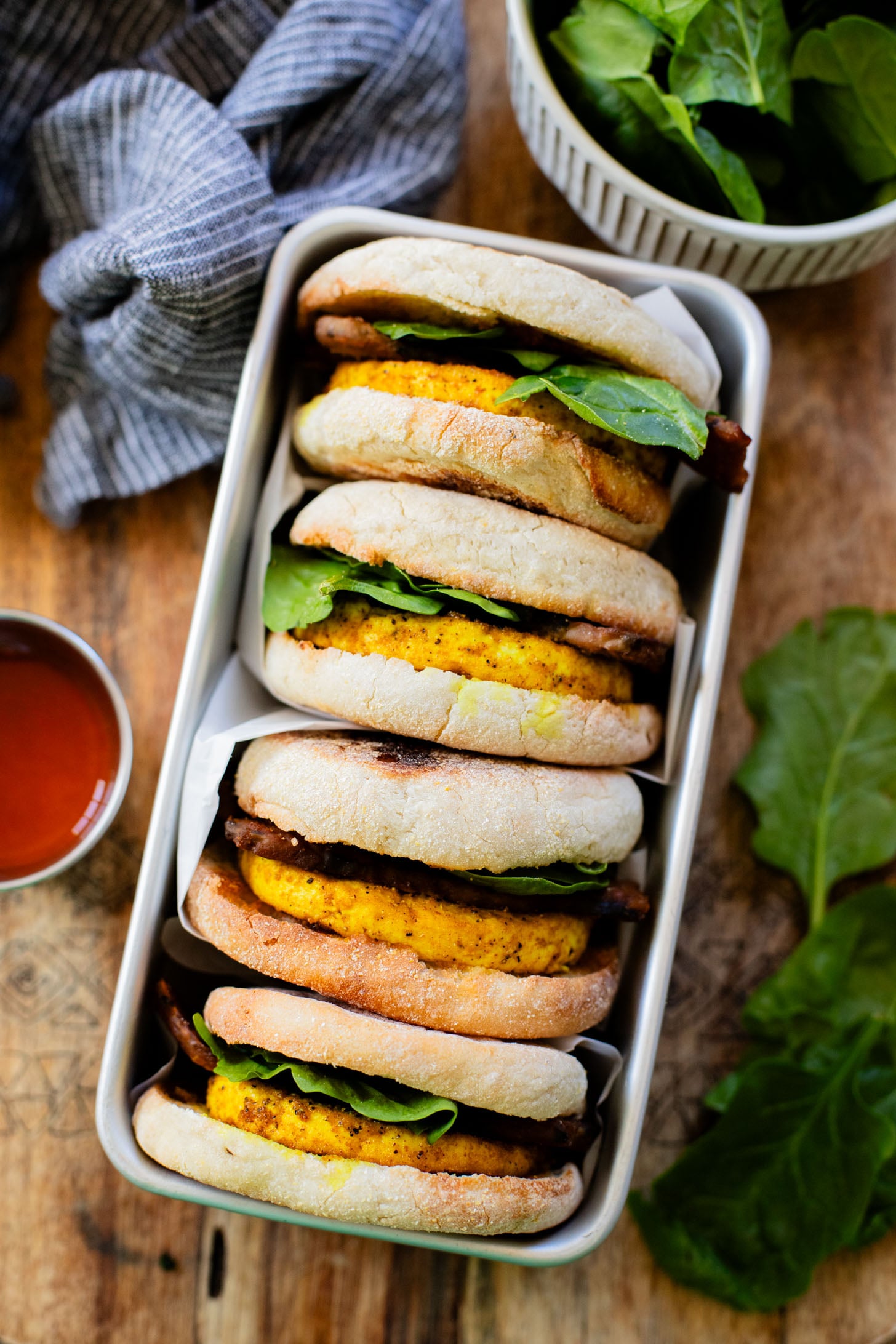 These Tofu Breakfast Sandwiches are the perfect breakfast on the go. Layered with seasoned tofu, tempeh bacon and spinach | ThisSavoryVegan.com