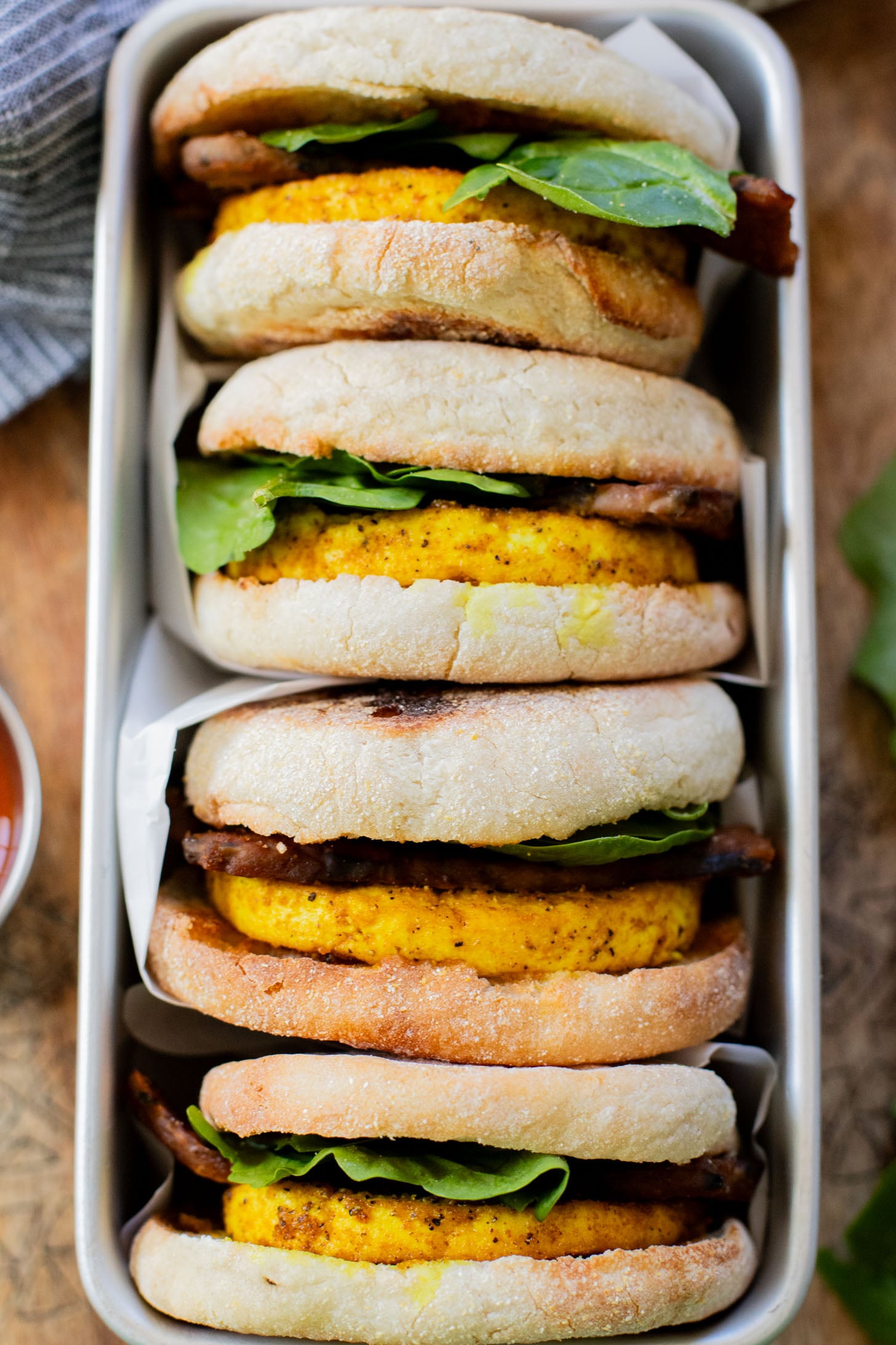 These Tofu Breakfast Sandwiches are the perfect breakfast on the go. Layered with seasoned tofu, tempeh bacon and spinach | ThisSavoryVegan.com
