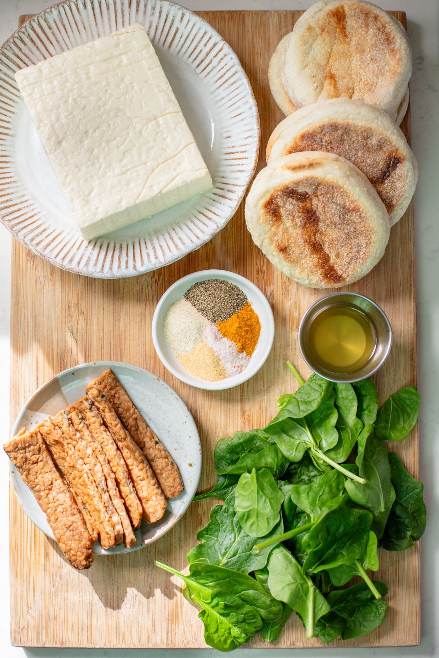 These Tofu Breakfast Sandwiches are the perfect breakfast on the go. Layered with seasoned tofu, tempeh bacon and spinach | ThisSavoryVegan.com