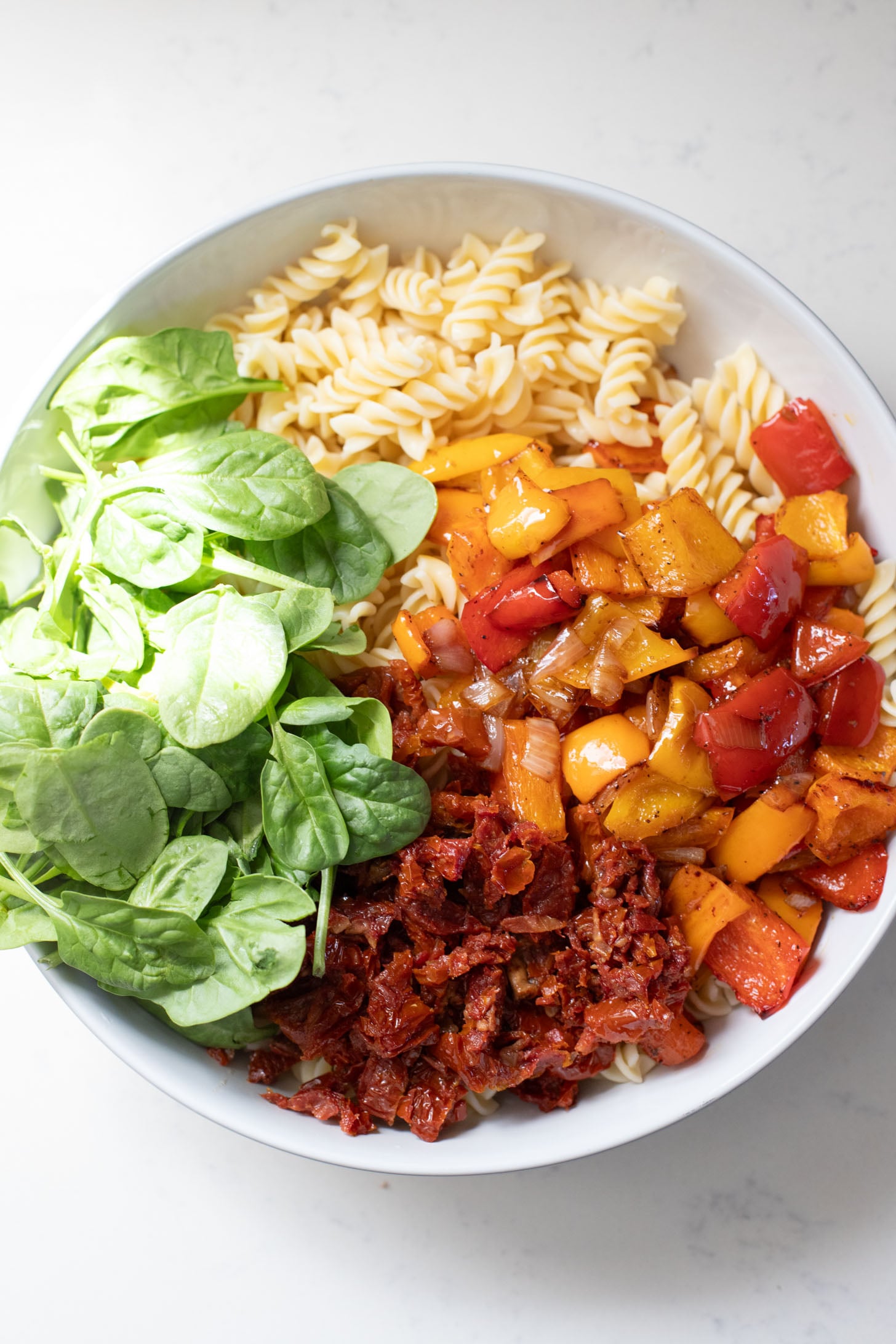 This Roasted Pepper Pasta Salad is simple but packed with flavor. Loaded with pasta, sun-dried tomatoes, roasted peppers and a light dressing | ThisSavoryVegan.com