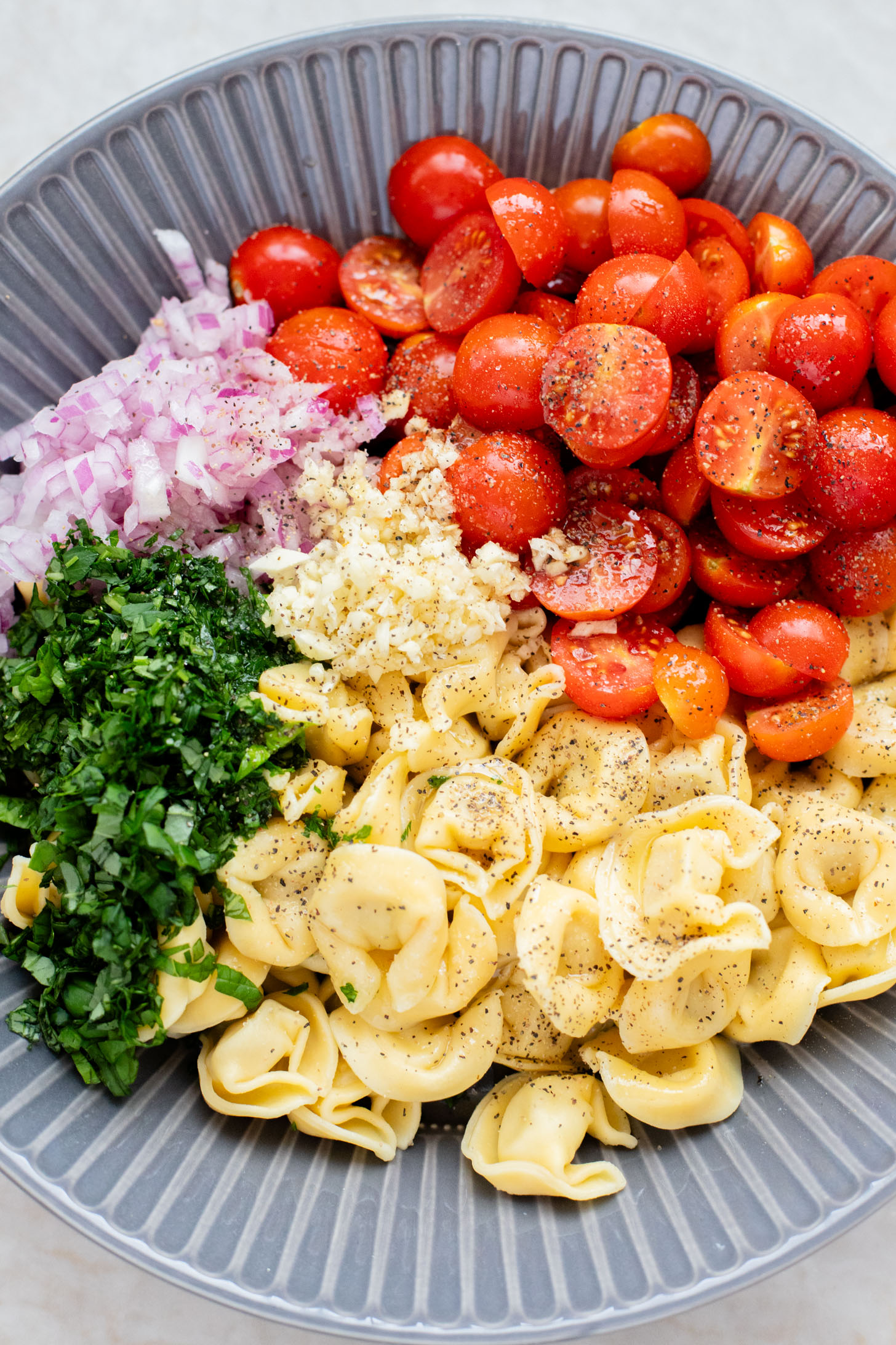 This Tomato Basil Tortellini Salad is made with chilled vegan tortellini, cherry tomatoes, balsamic, garlic & fresh herbs. The perfect summer salad | ThisSavoryVegan.com