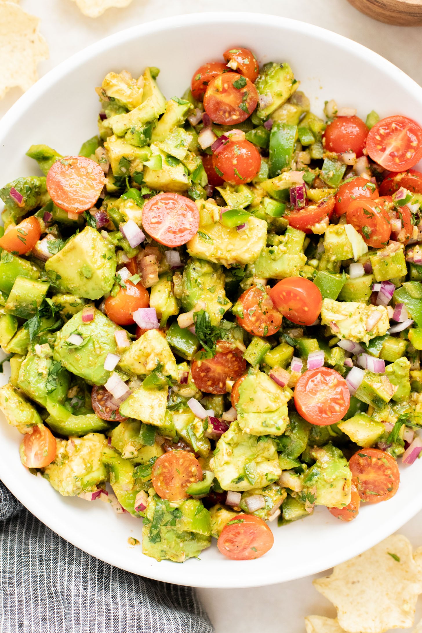This Avocado Tomato Salad is a hearty side dish or appetizer. Best served with tortilla chips for the perfect bite | ThisSavoryVegan.com
